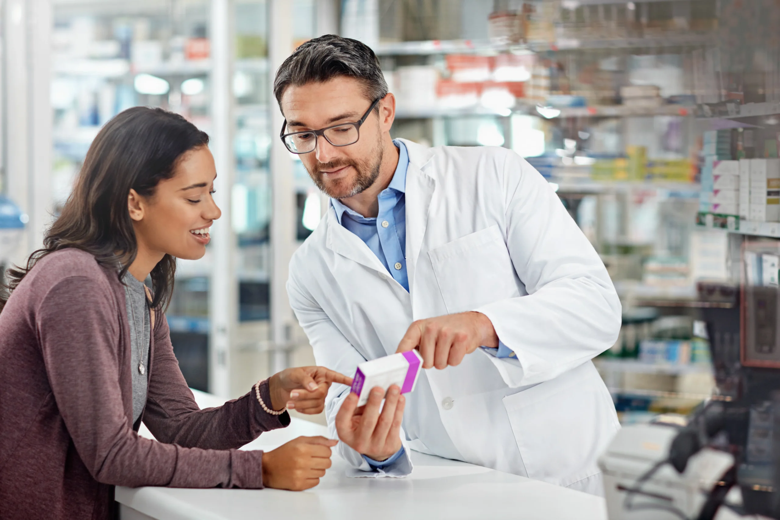 Pharmacist assisting a customer with compliant medication packaging.