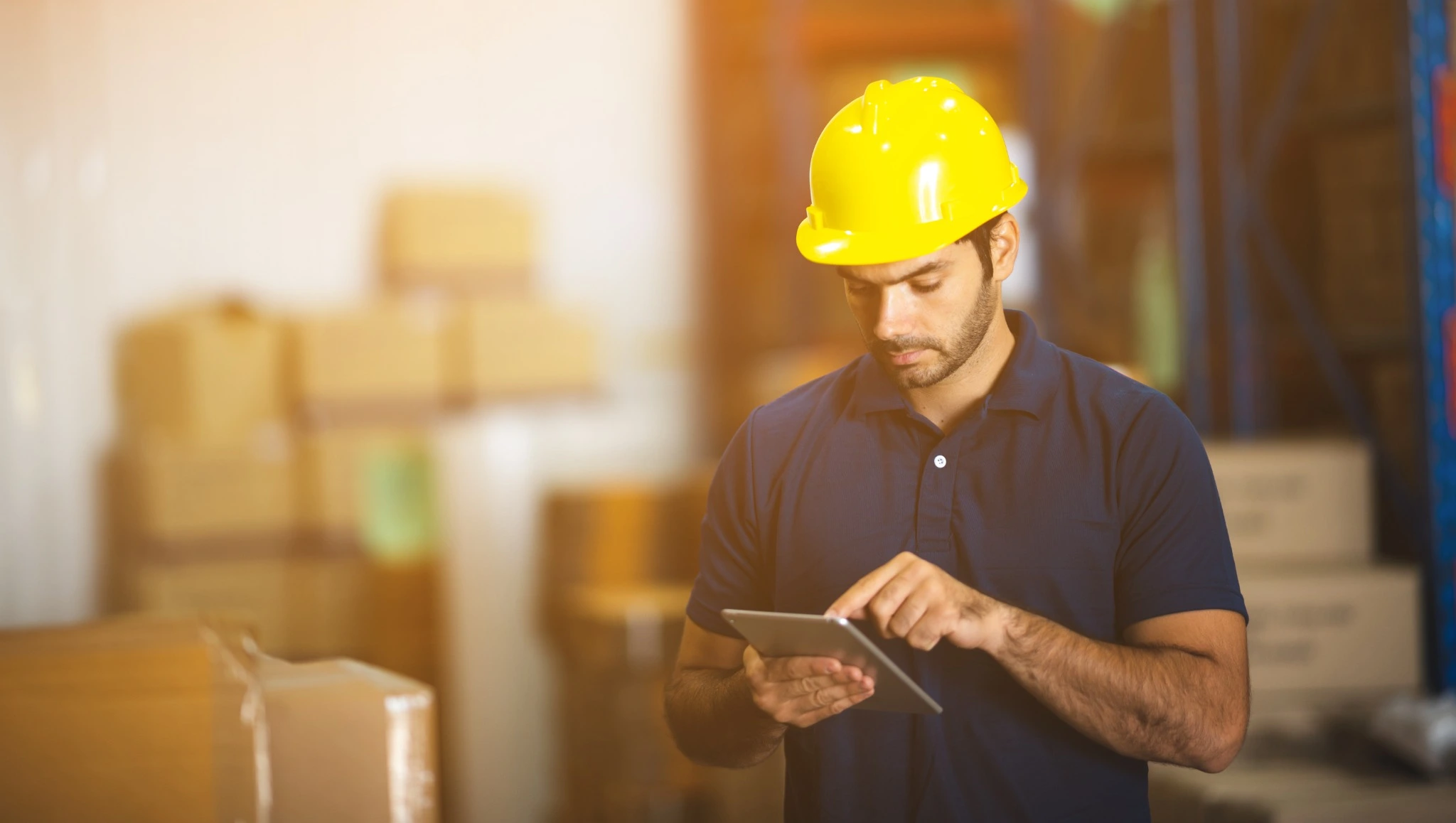 Warehouse worker using a tablet to track inventory and streamline logistics, showcasing the role of 3PL value-added services.