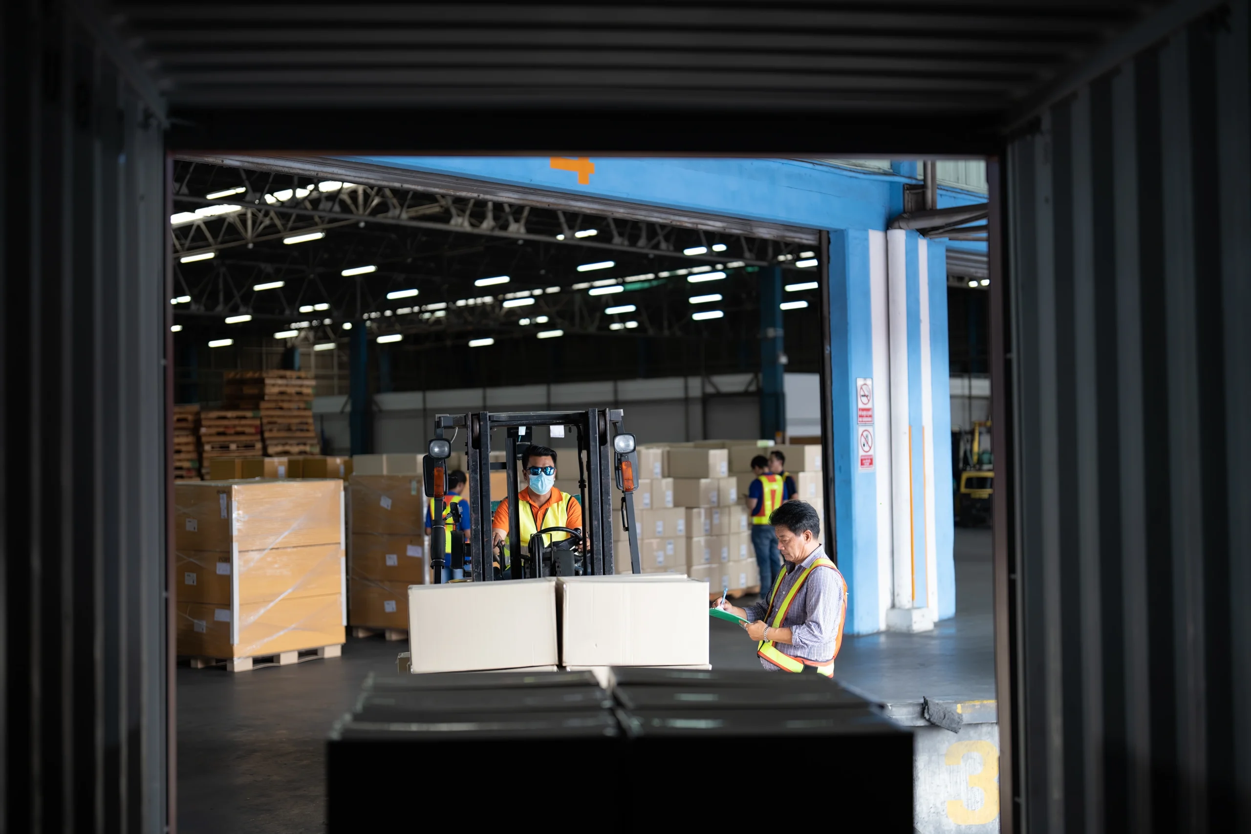 Workers managing cargo inside a warehouse connected to a Foreign Trade Zone, ensuring smooth operations and compliance.