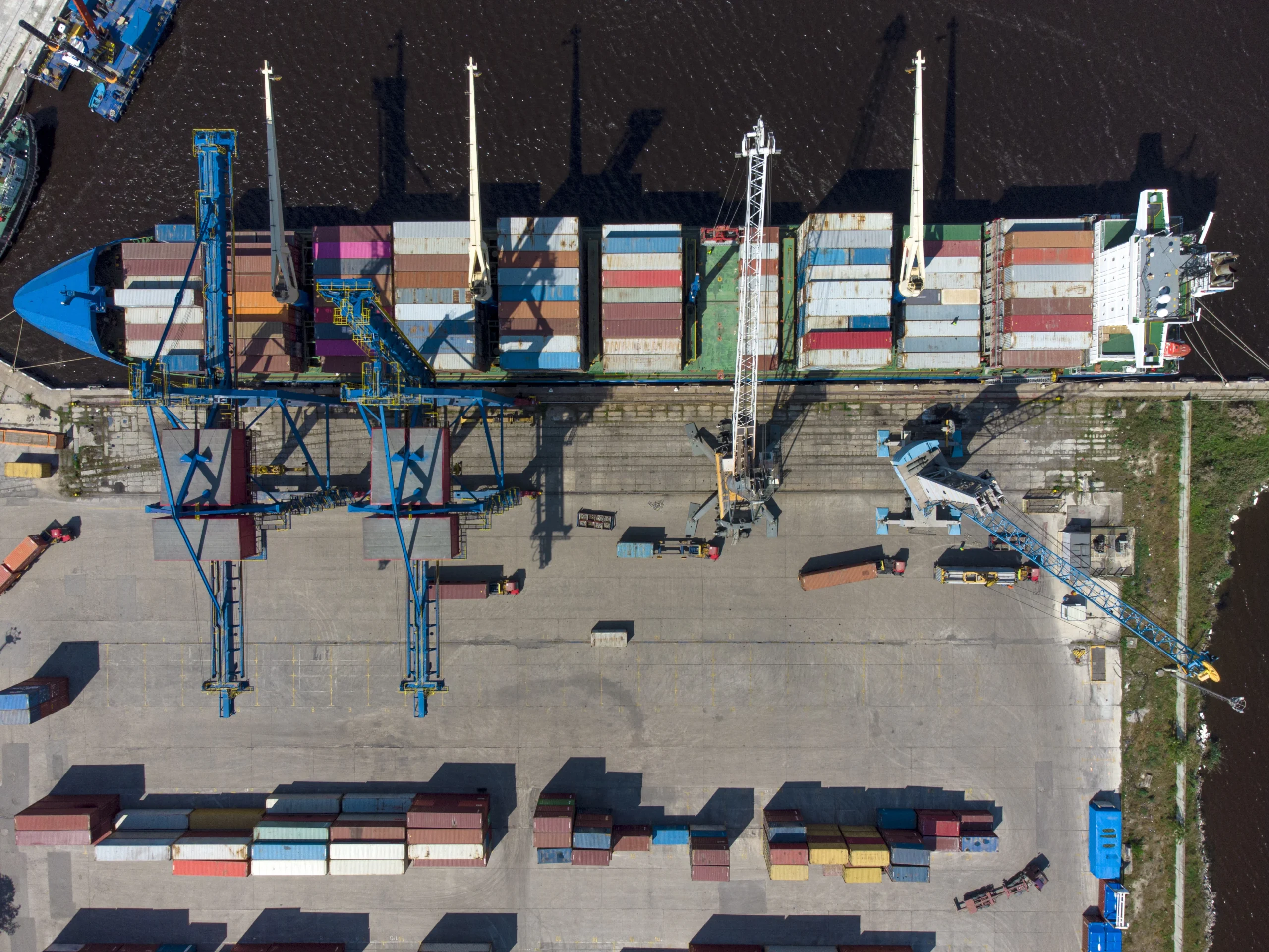 Aerial view of a cross dock center unloading cargo from a container ship.