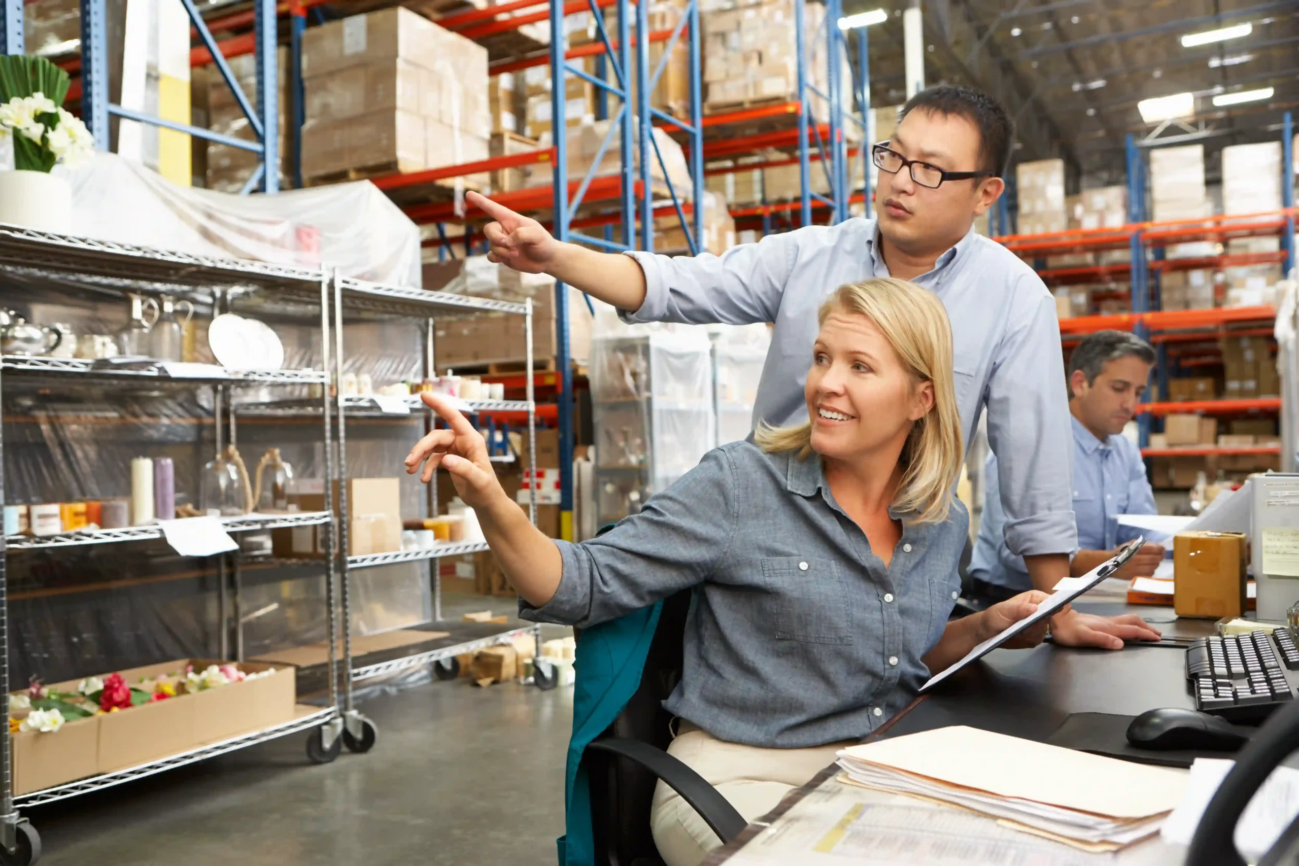 Warehouse managers discussing stock logistics, showcasing an inventory management system use case in supply chain management.
