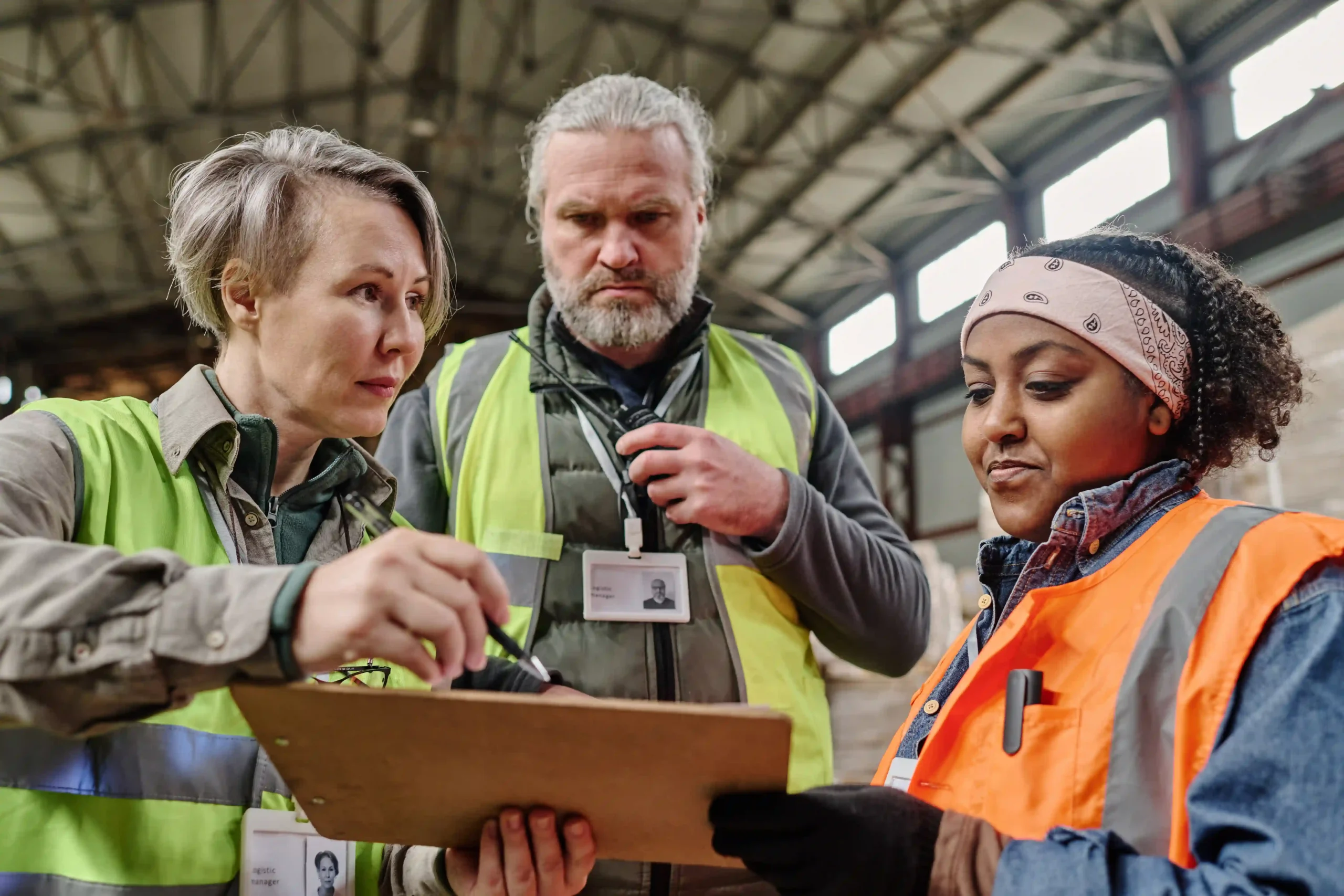 Warehouse team analyzing a customs annual report to verify import and export compliance in a logistics facility.