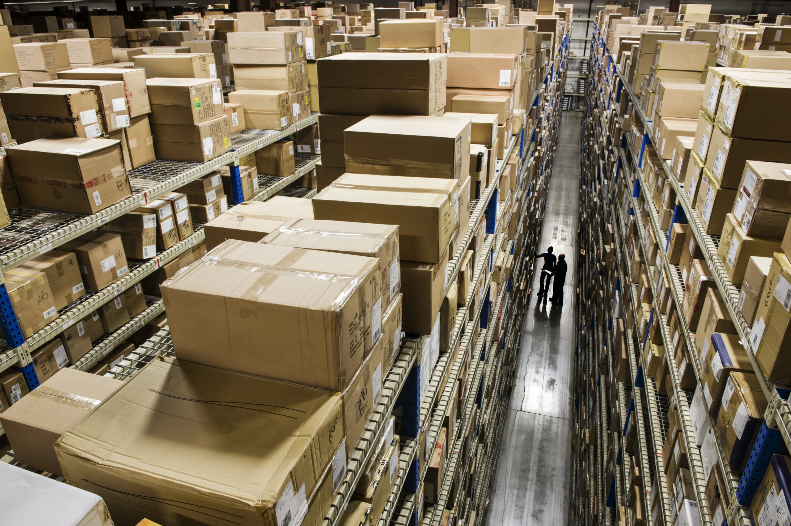 A high-angle view of a cross docking distribution center with towering storage racks filled with packages, optimizing logistics and inventory management.