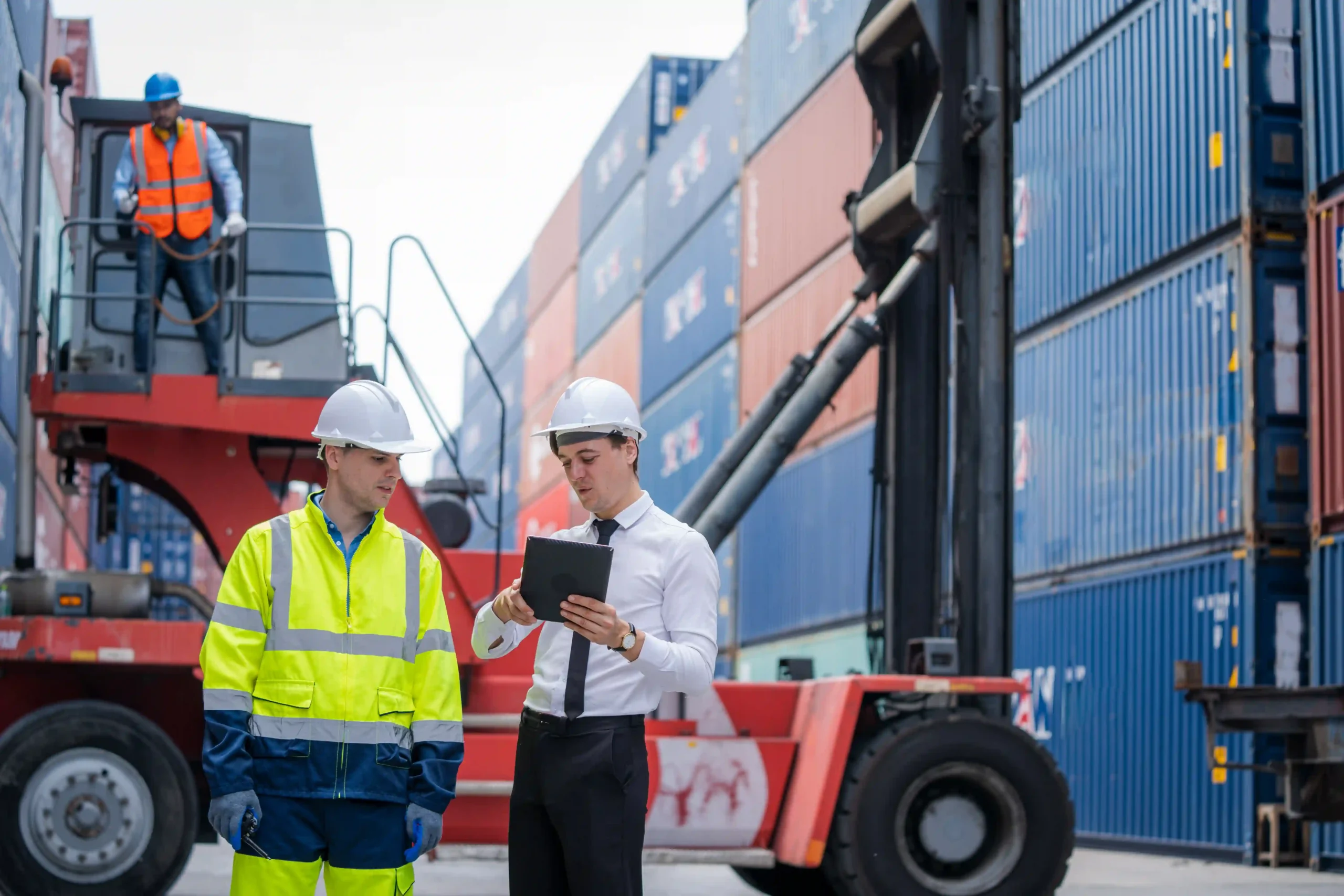 A logistics manager working with technicians at a container yard, optimizing international universal contract logistics.