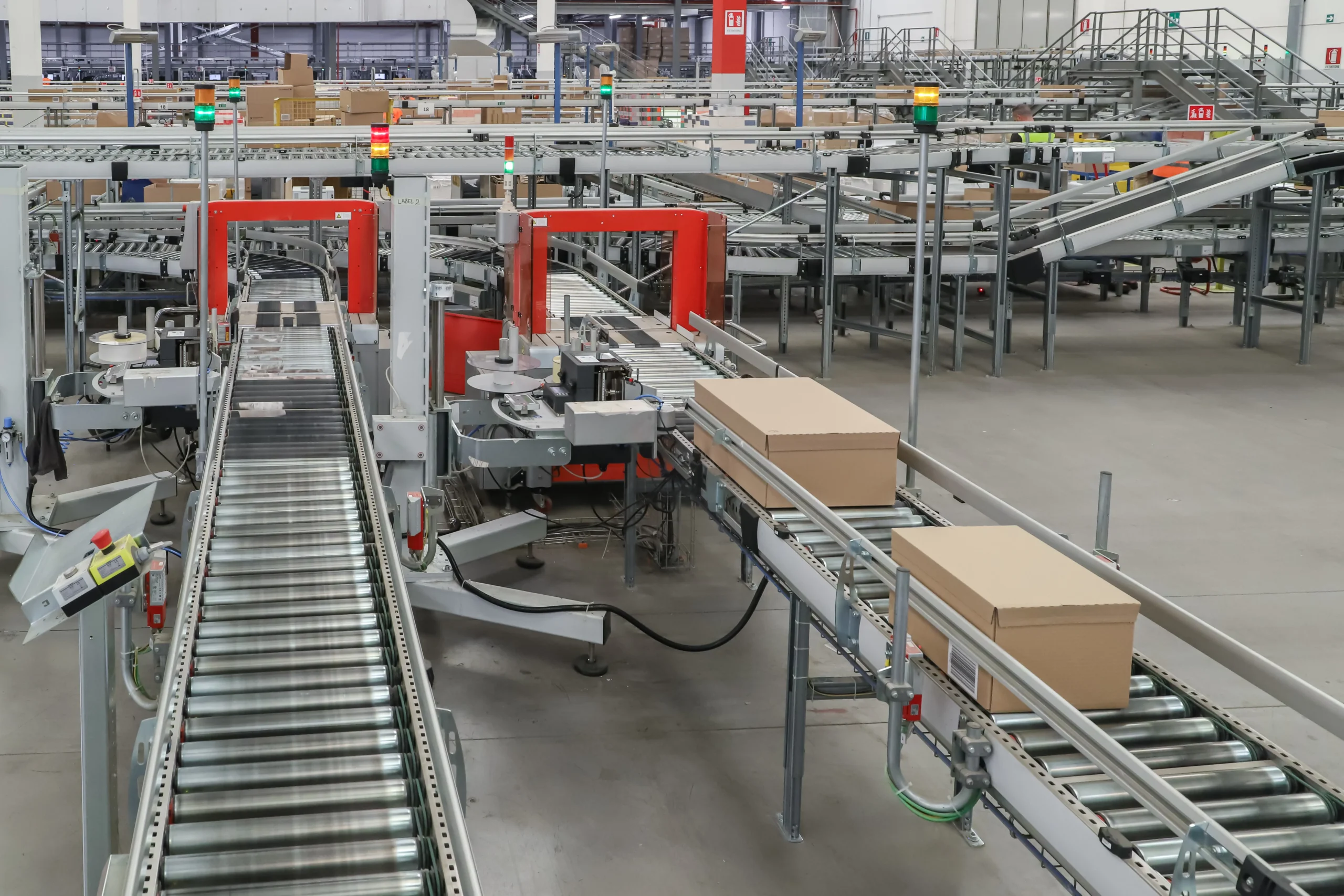A modern cross docking distribution center using automated conveyor belts to streamline the movement of goods for faster order fulfillment.