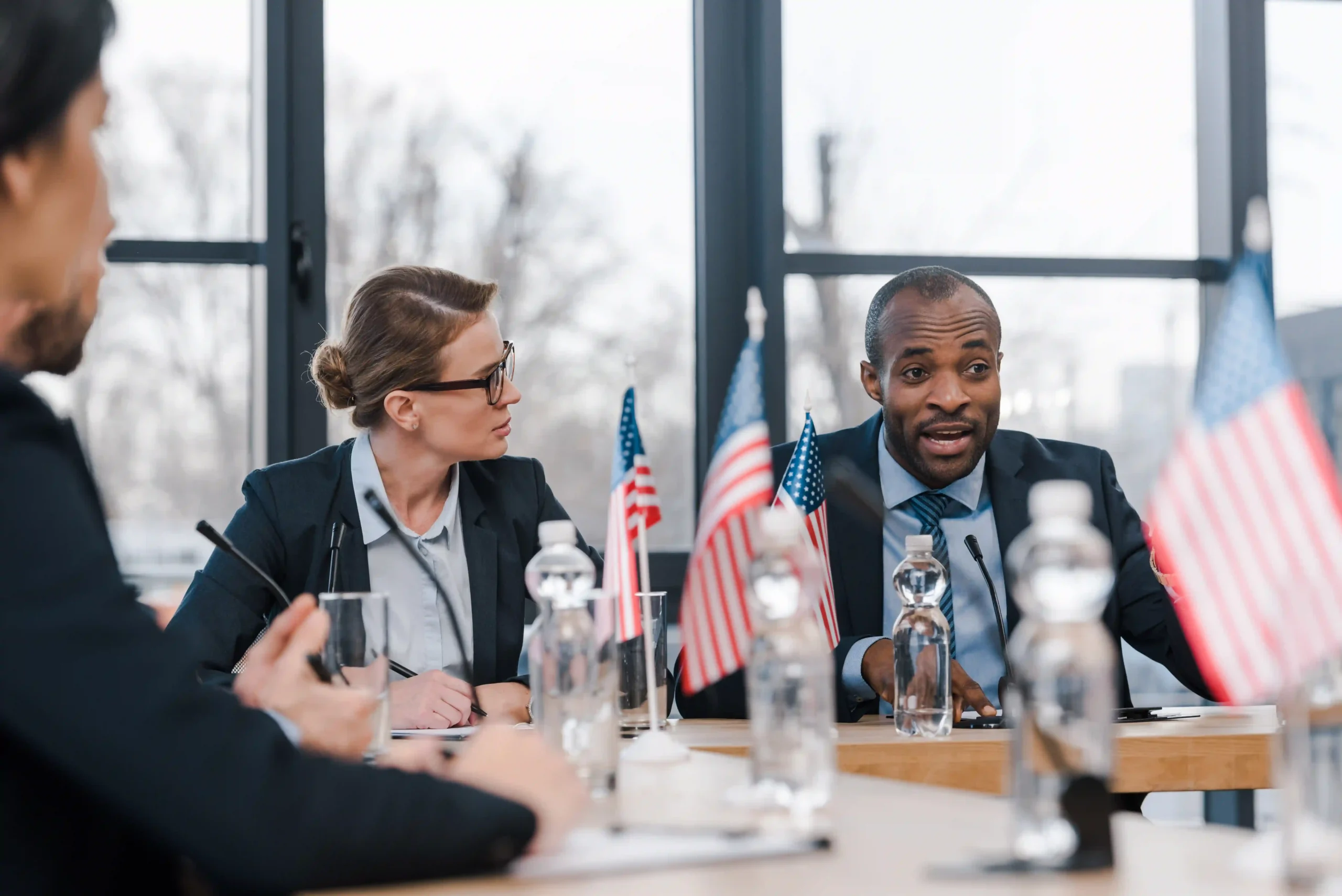 A businesswoman at an international trade meeting discussing Trump tariffs and their effect on supply chains.