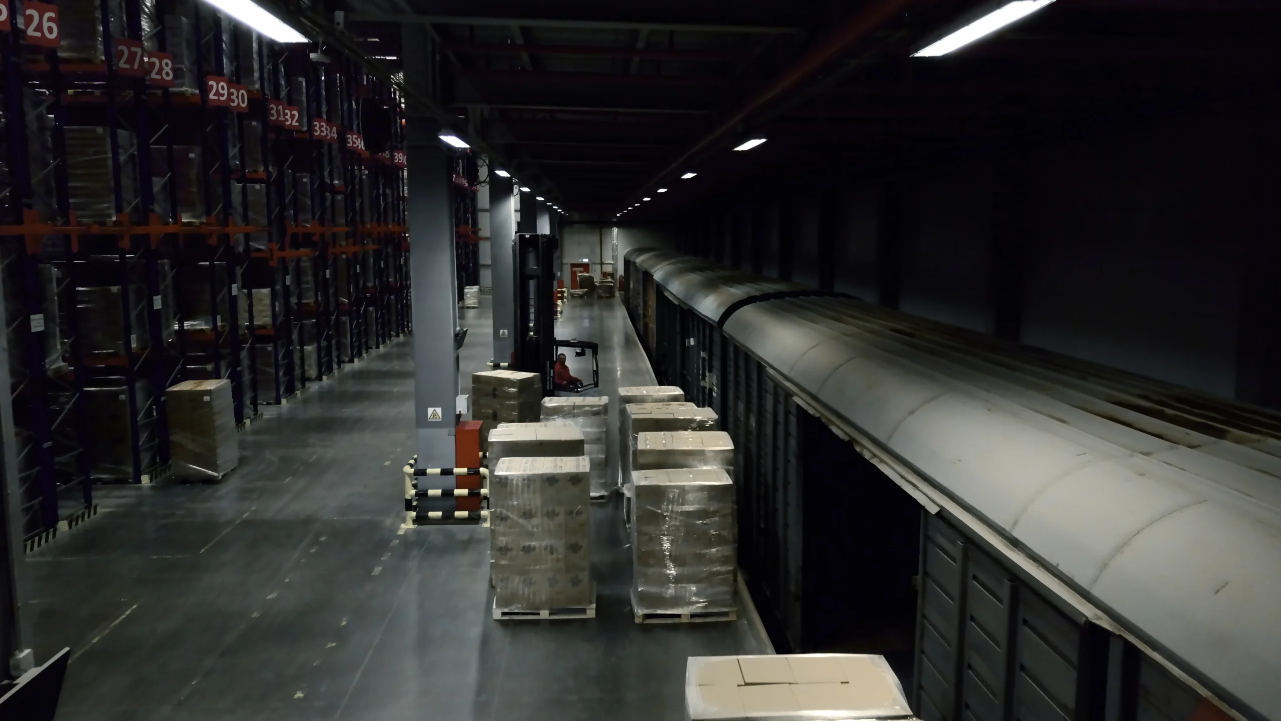 Unloading freight trains in a cross-docking warehouse with forklifts and streamlined logistics processes.