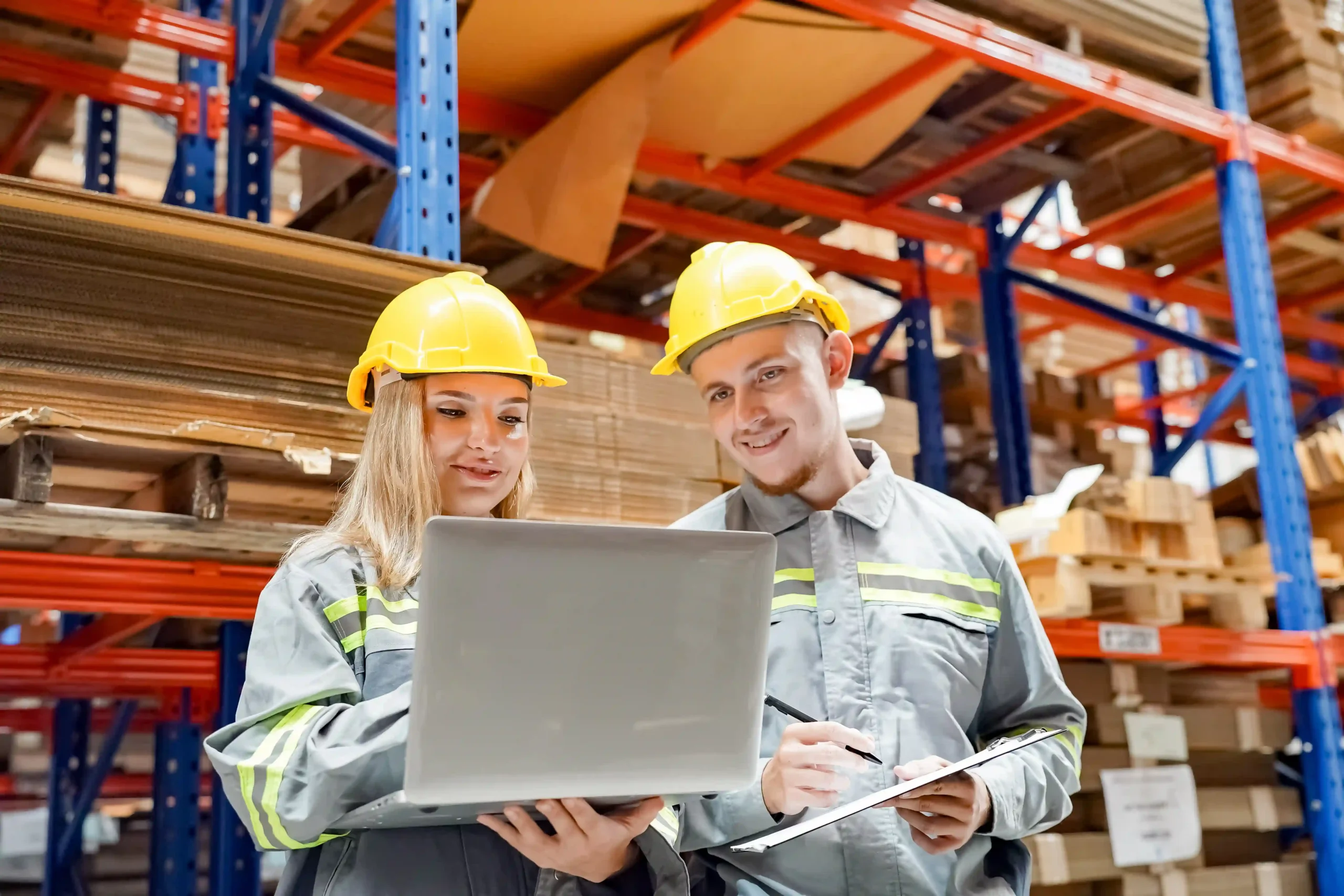 A warehouse logistics expert analyzing supply chain data with a laptop, illustrating the importance of a warehouse management system questionnaire in warehouse optimization.