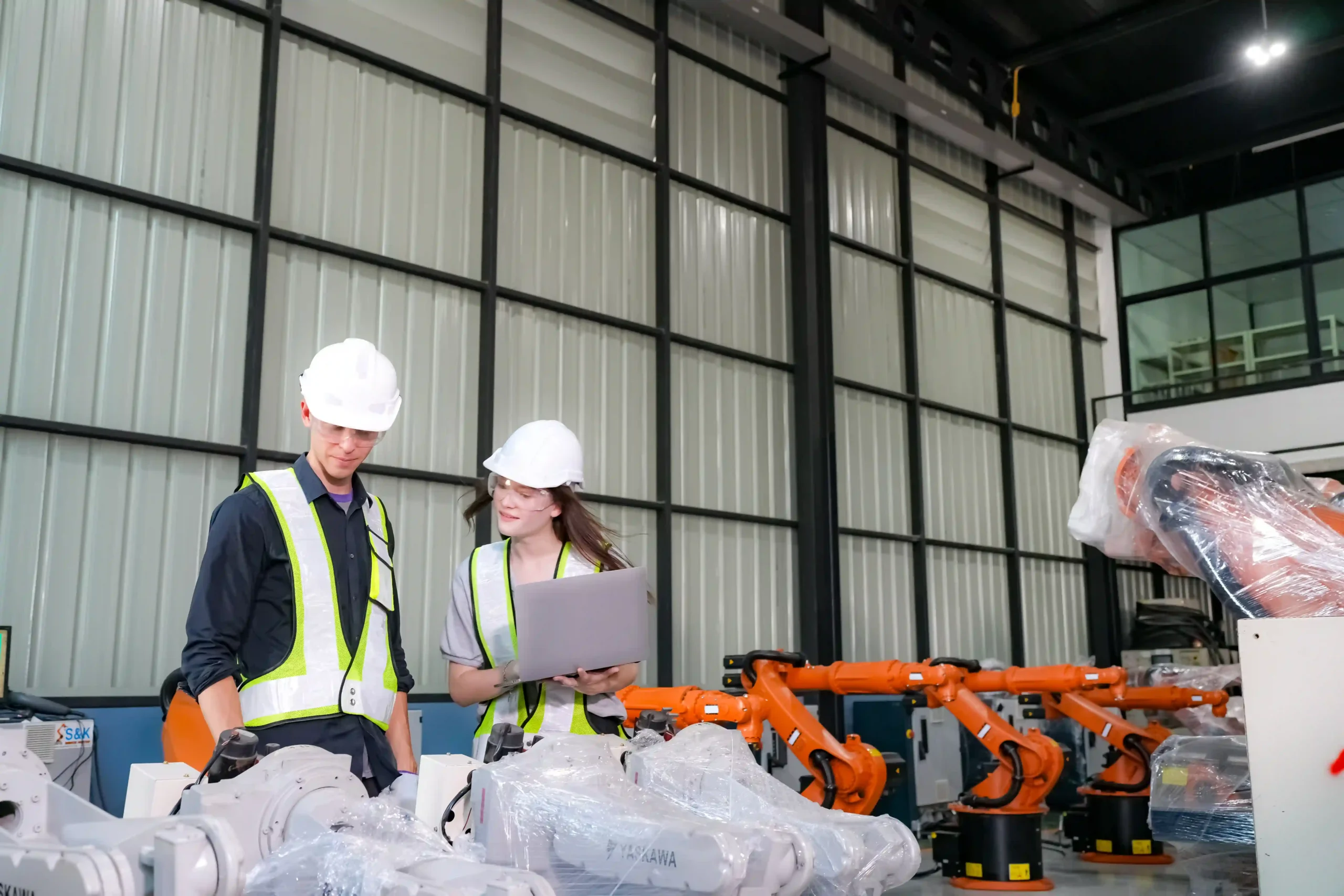 Engineer analyzing robotic automation in manufacturing, demonstrating technology's role in solving supply chain optimization challenges.