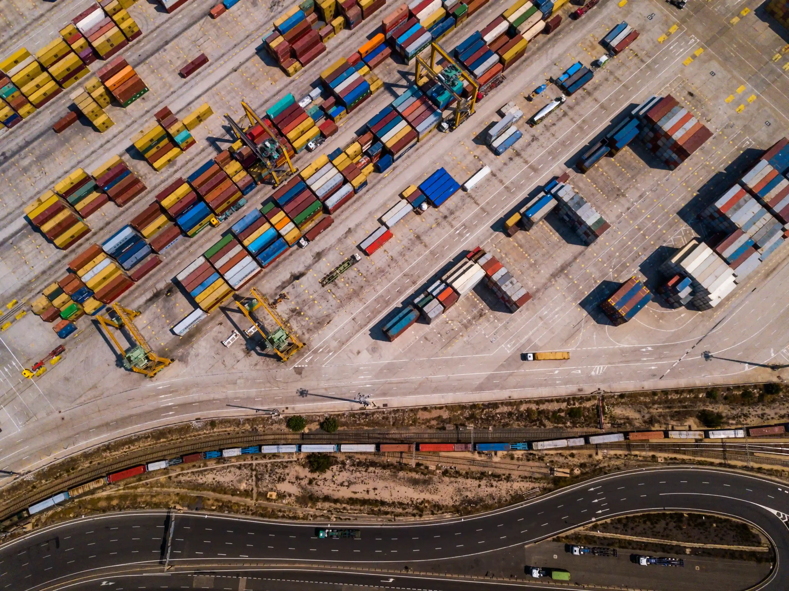 Industrial cargo area with stacked shipping containers, highlighting how businesses utilize duty deferral and tariff inversion (FTZ) to optimize trade costs.
