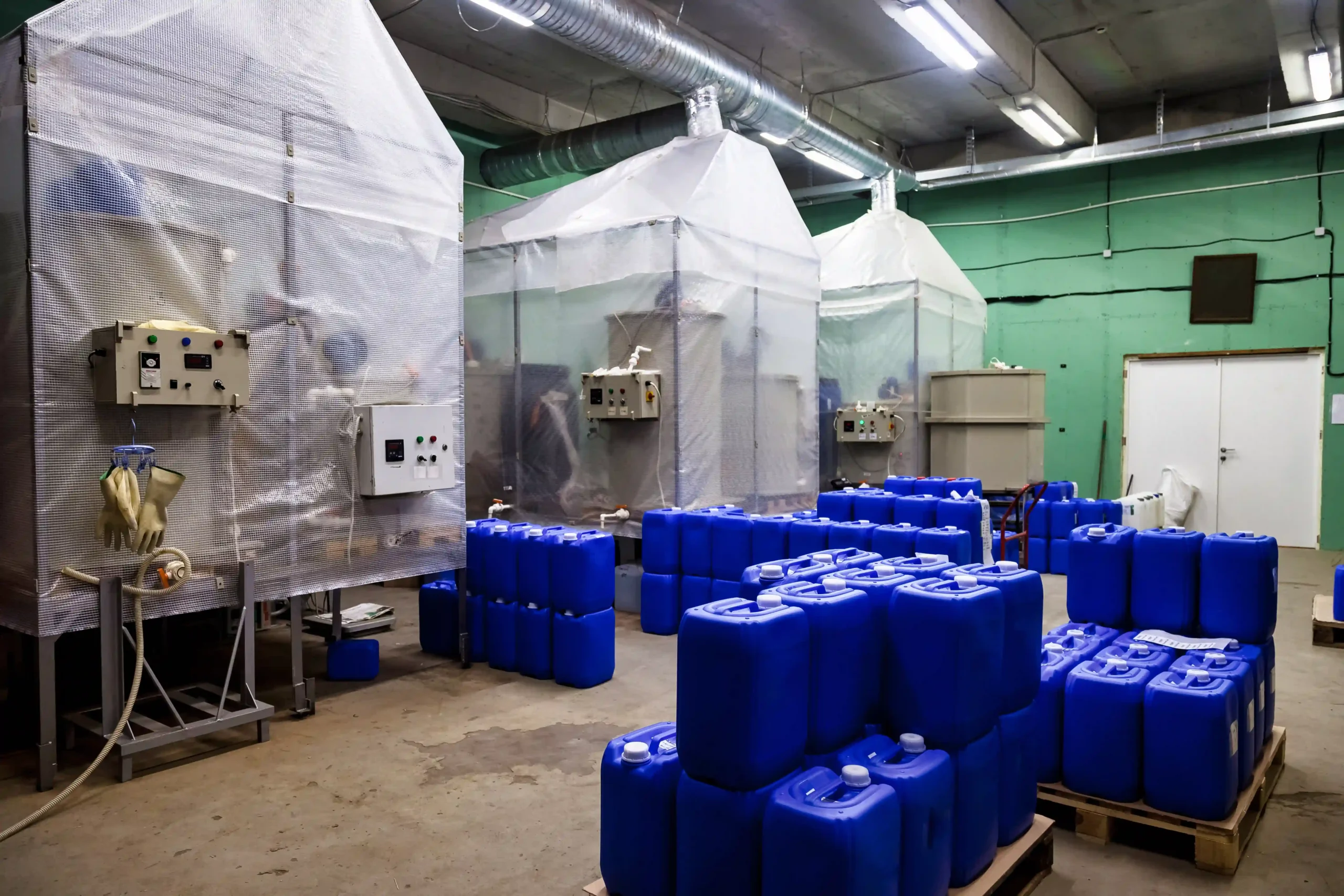Chemical warehouse interior with hazardous materials safely stored in blue containers.