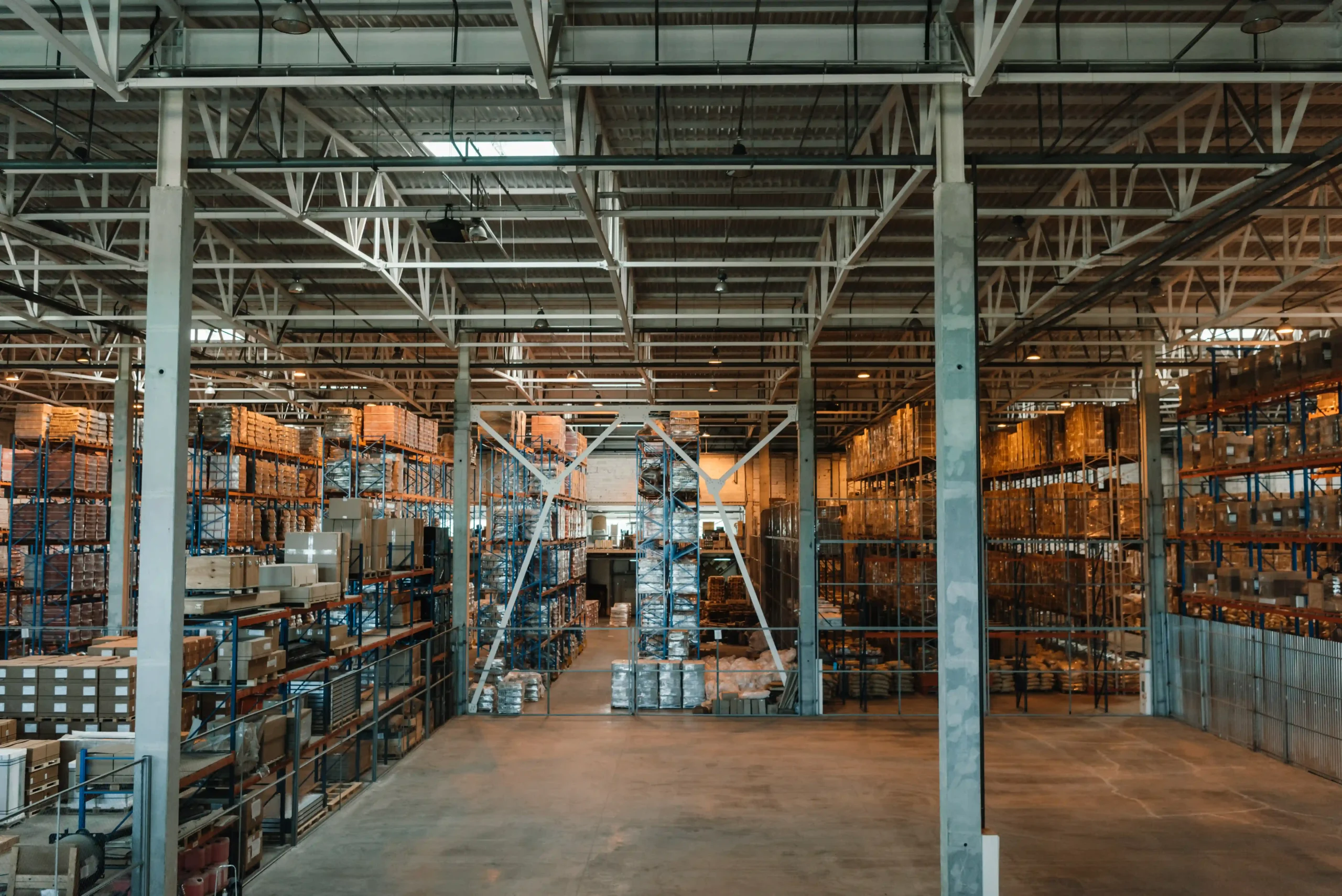 A modern high-bay warehouse with stacked pallets, metal racks, and an optimized layout for inventory storage.