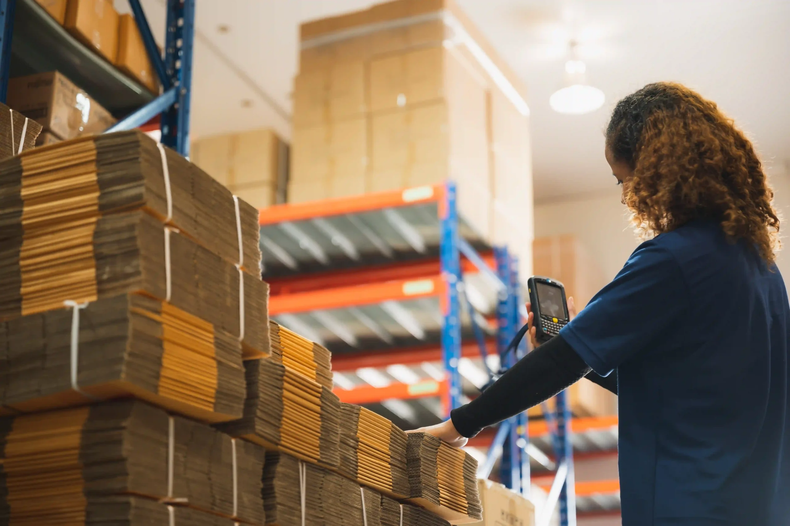 A warehouse worker using a barcode scanner to track stock, demonstrating the importance of FTZ inventory management best practices.