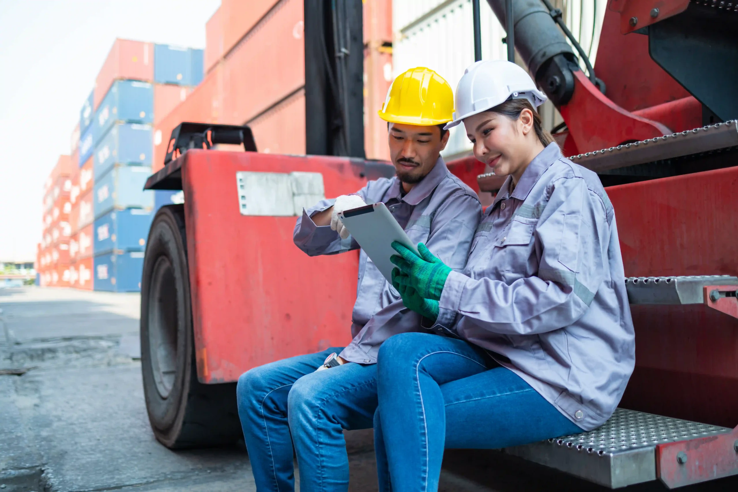 Two warehouse workers reviewing a digital report, demonstrating the benefits of custom report design in logistics.