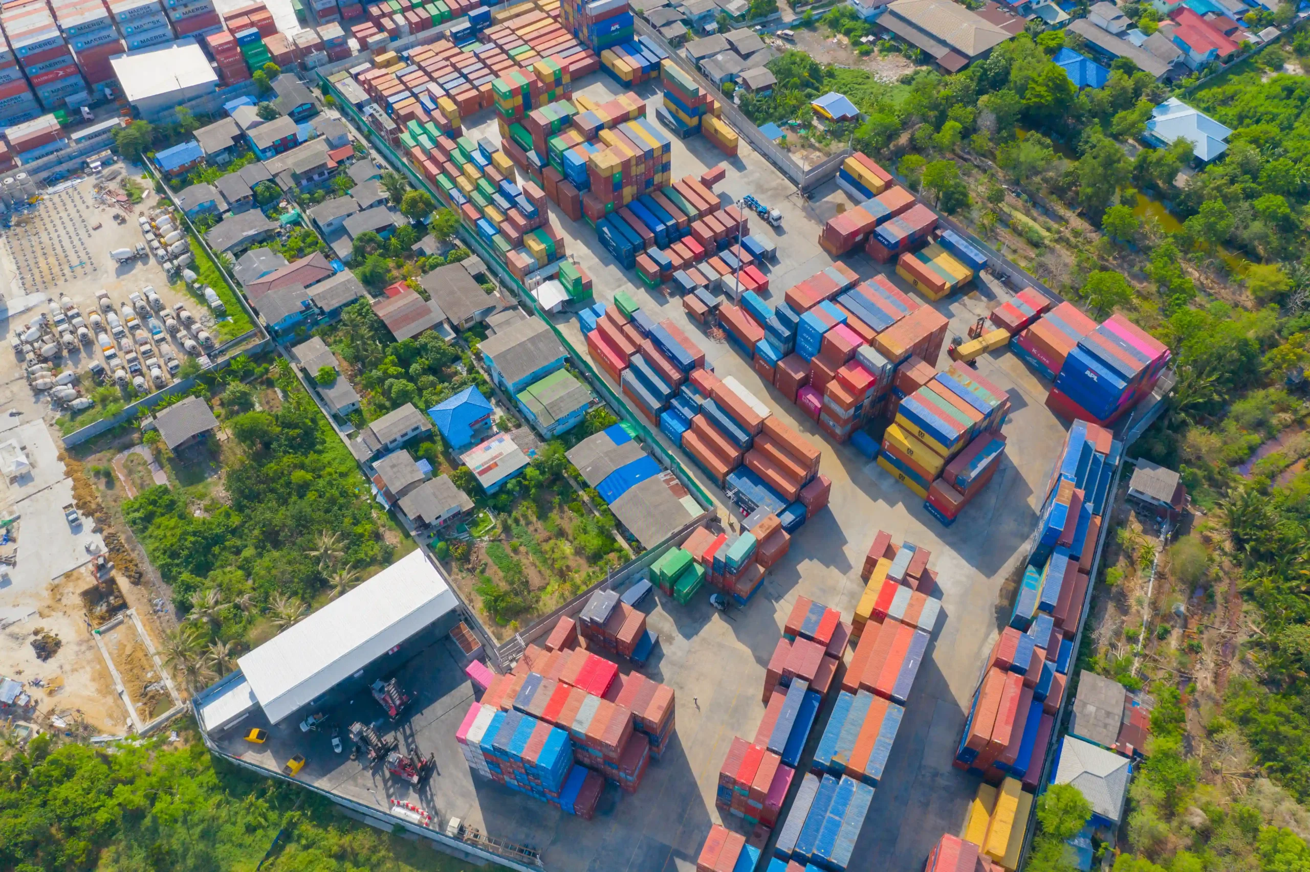 Logistics hub with organized shipping containers, representing the role of duty deferral and tariff inversion (FTZ) in modern import-export operations.