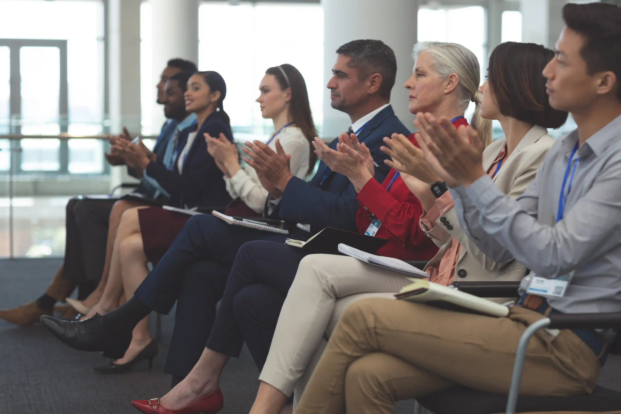 Supply chain leaders from various industries applauding a presentation on AI in logistics at the Supply Chain Innovation Conference.