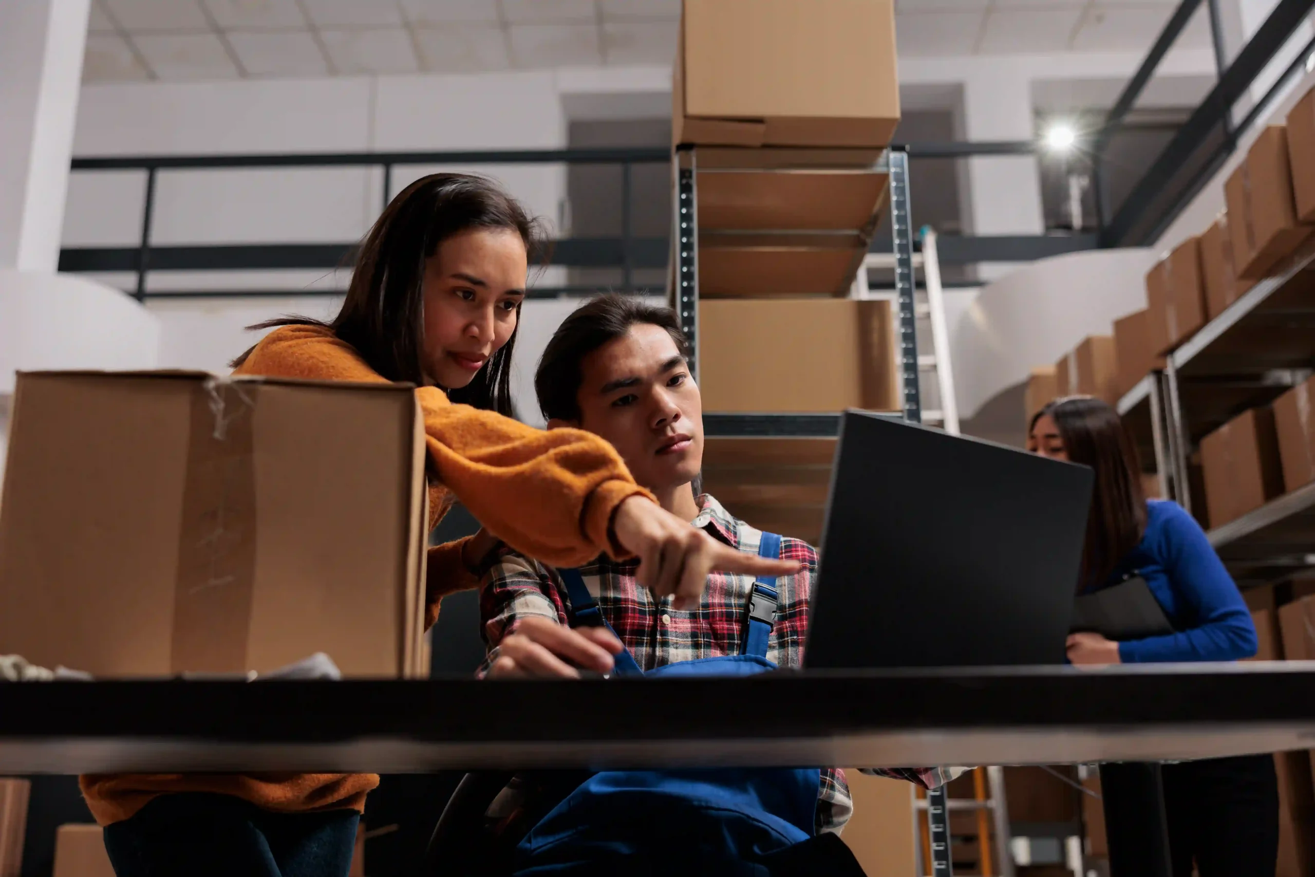 Warehouse managers analyzing supply chain data with custom report development to improve order fulfillment efficiency.