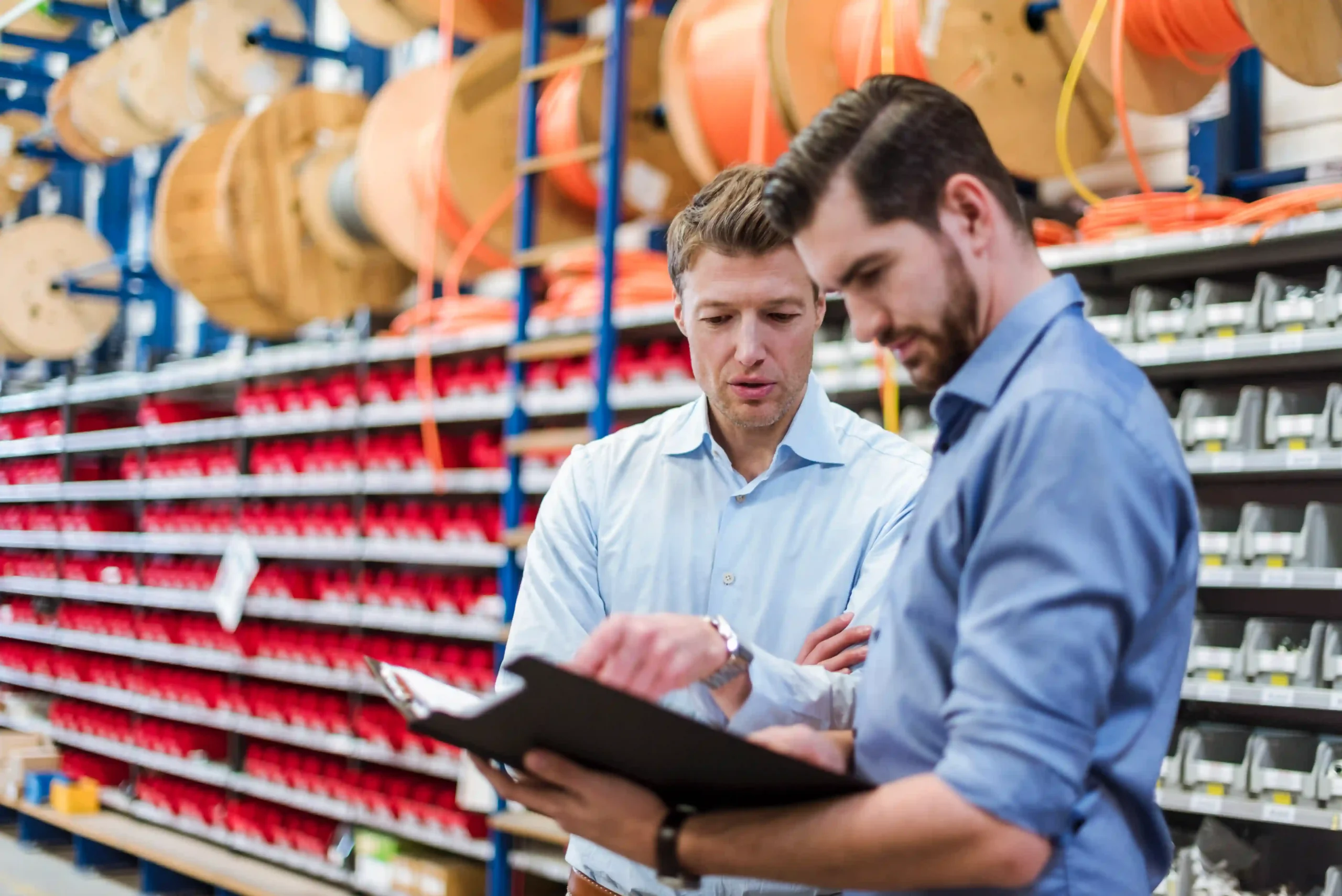 Logistics professionals discussing supply chain visibility and optimization strategies in a warehouse.