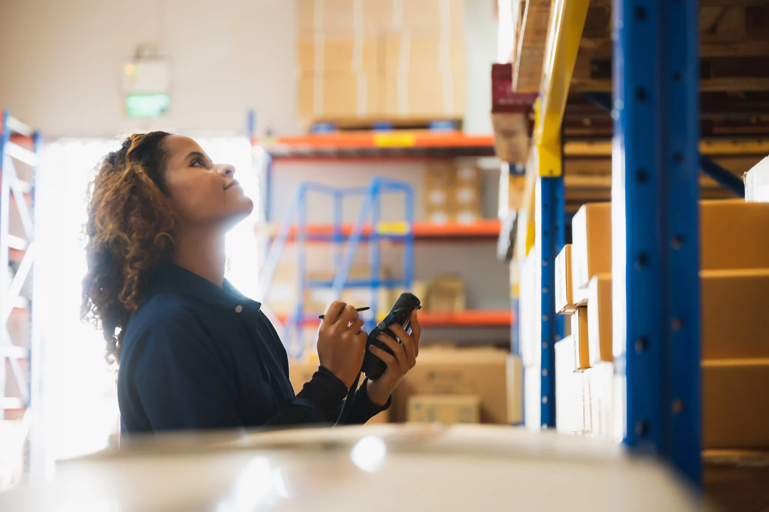 A worker organizing and inspecting warehouse stock, applying FTZ inventory management best practices for streamlined logistics.