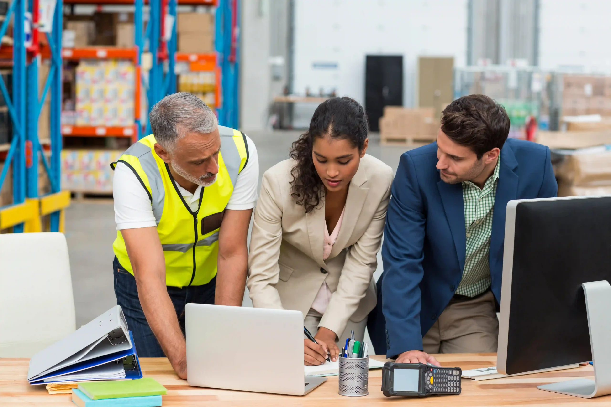 A team of logistics and supply chain professionals collaborating in an office, managing compliance and operations in heavy regulated industries.