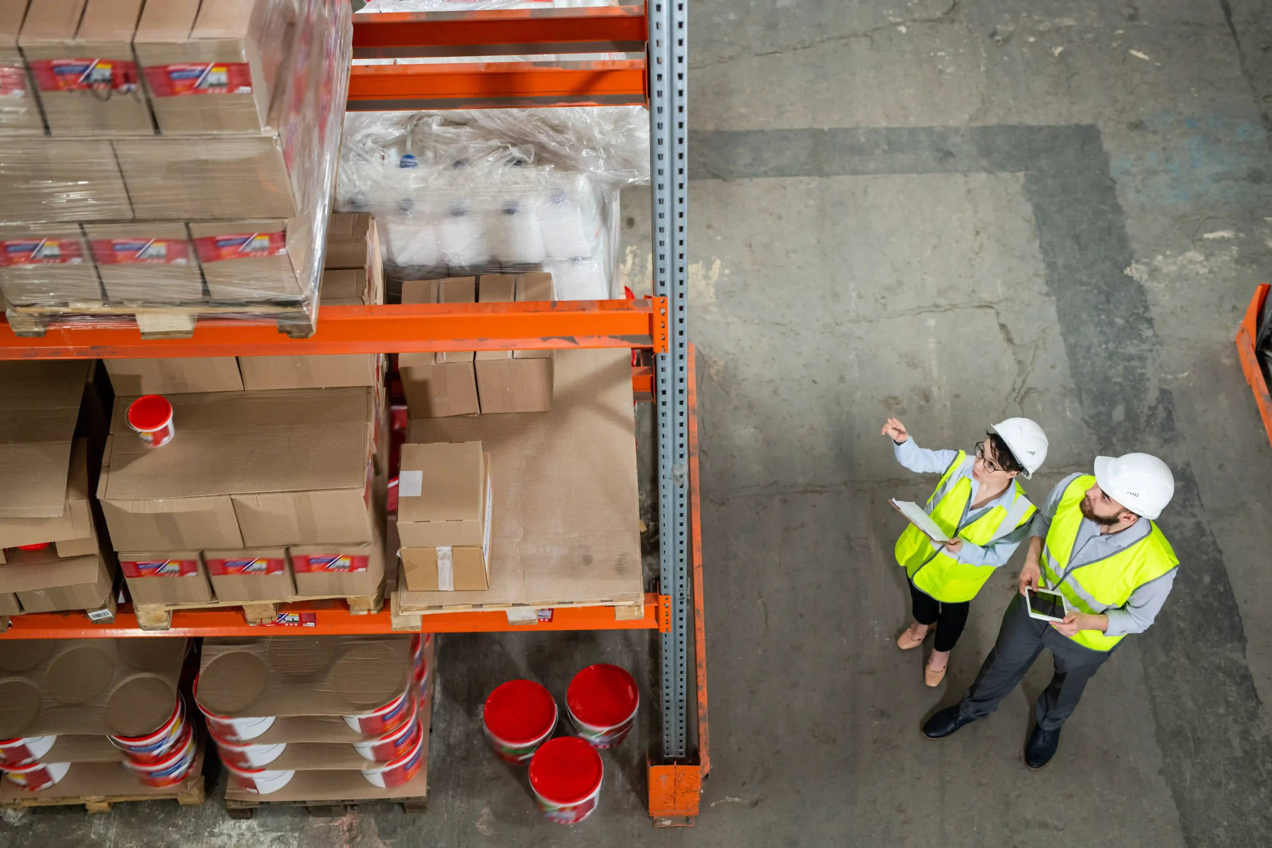 Warehouse supervisors reviewing high-volume stock near loading docks, illustrating that cross docking is most closely related to agile supply chain planning.