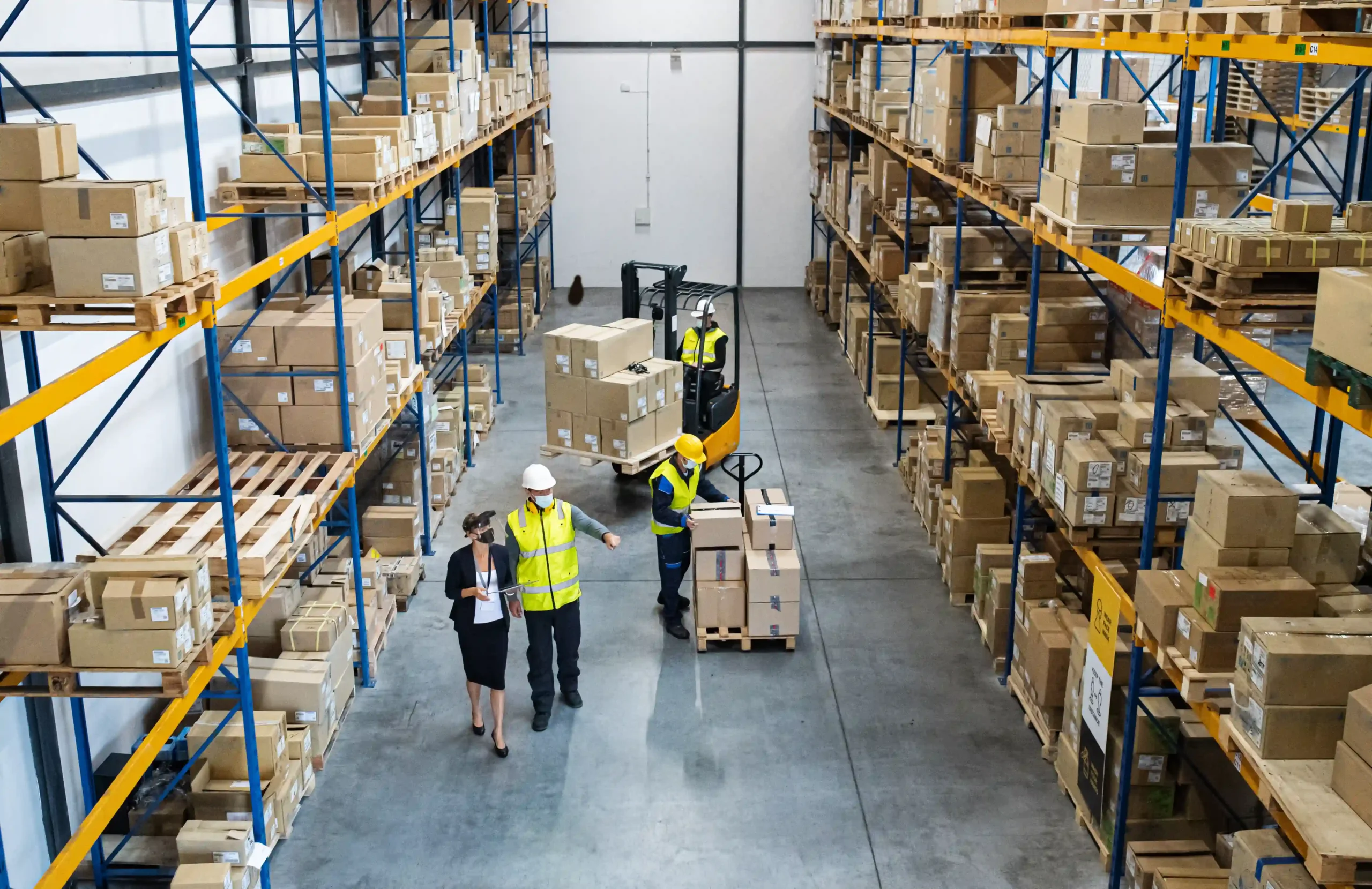 Overhead view of FTZ in USA warehouse workers coordinating shipments and inventory logistics.