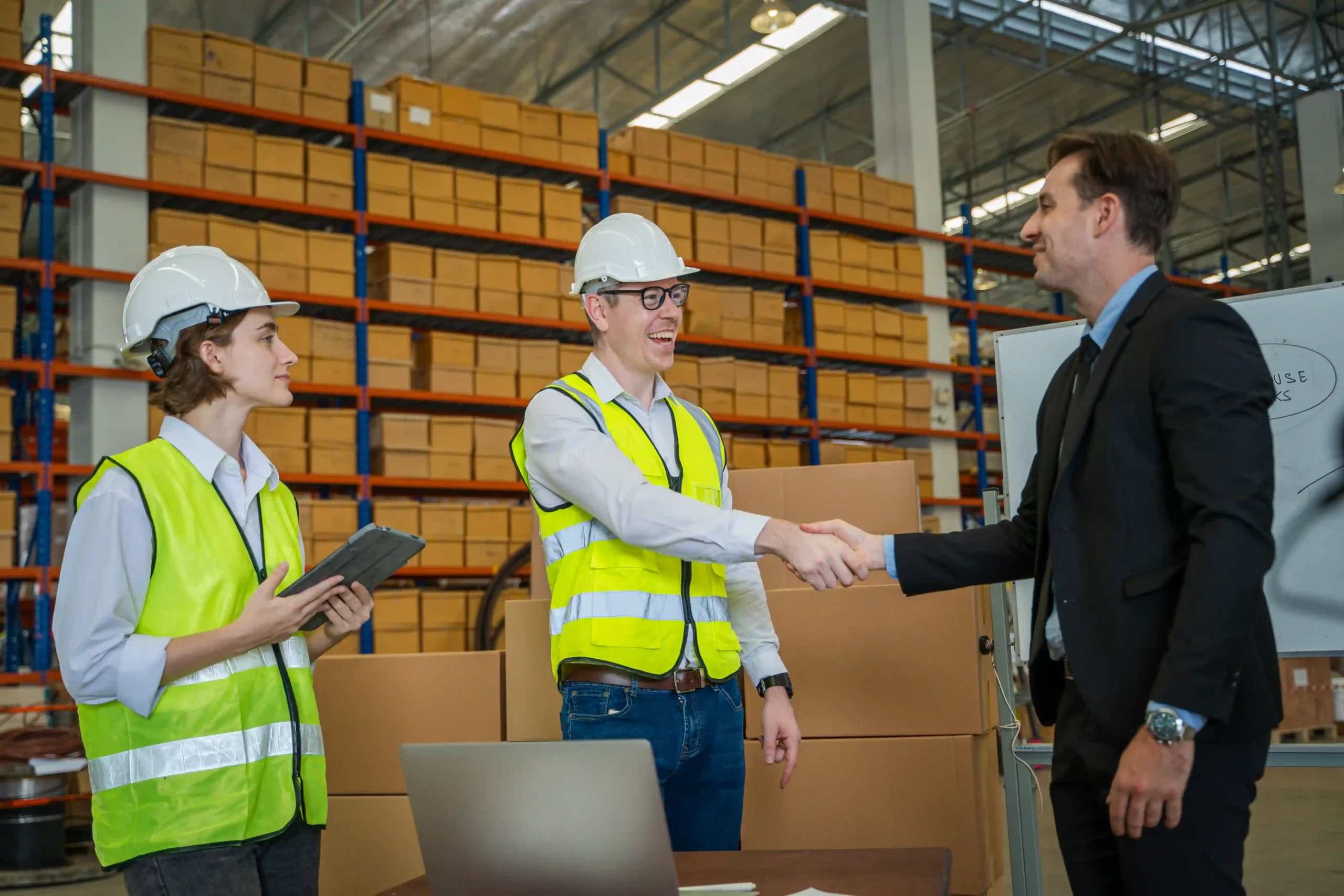 Logistics managers reviewing 3PL contract logistics performance metrics in a distribution center