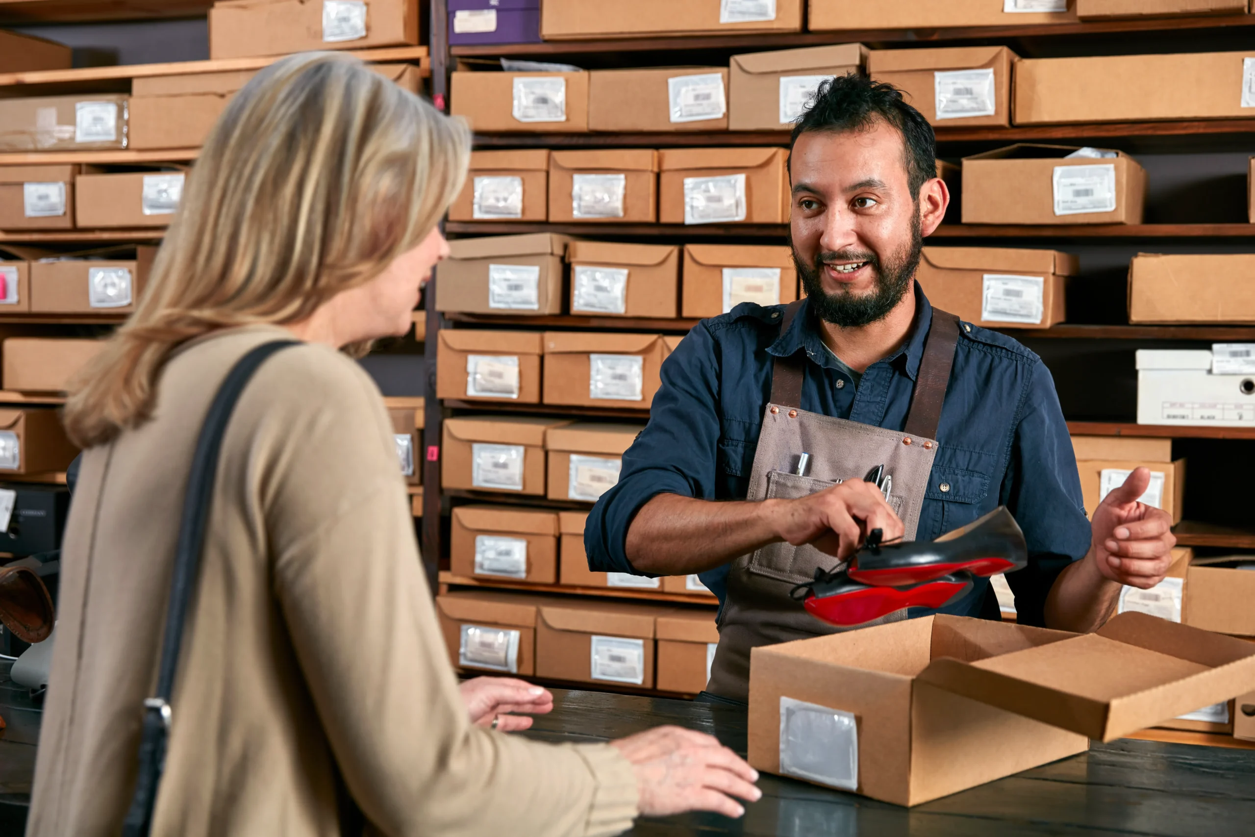 Retail staff using an order fulfillment dashboard to process shoe return in a stockroom