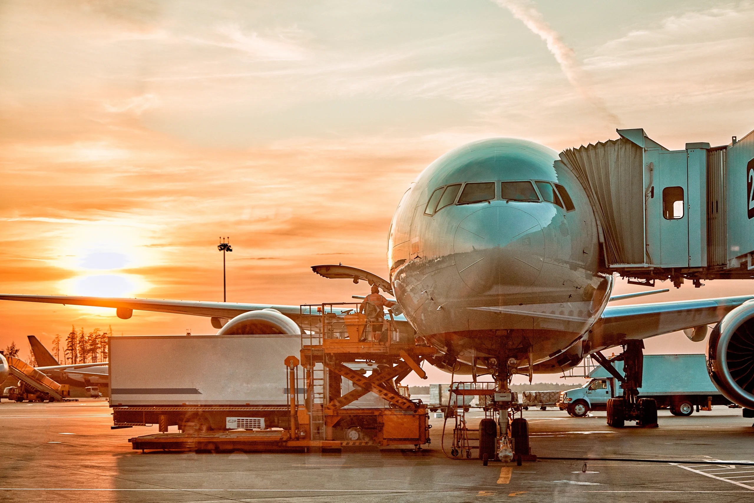 Commercial airplane docked at airport terminal during air transportation logistics operation at sunrise