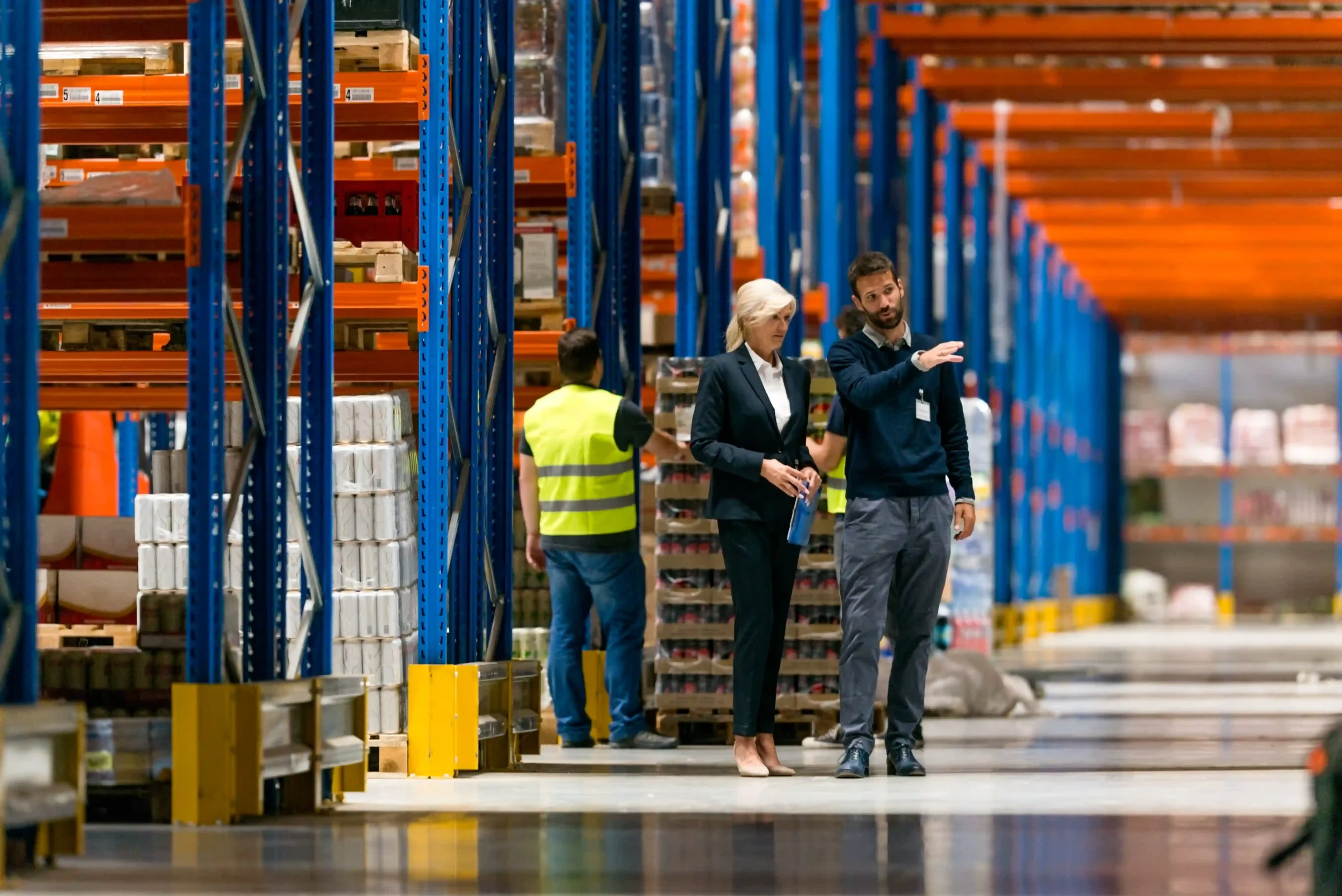 Logistics managers reviewing warehouse layout and operations to ensure effective warehouse logistics optimization across all functions.