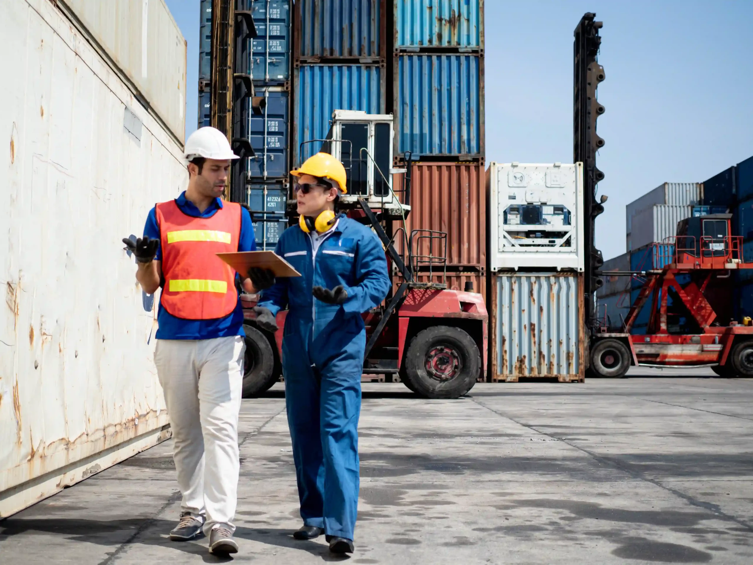 Supply chain professionals discussing container logistics at a freight terminal, illustrating 3PL explained operations