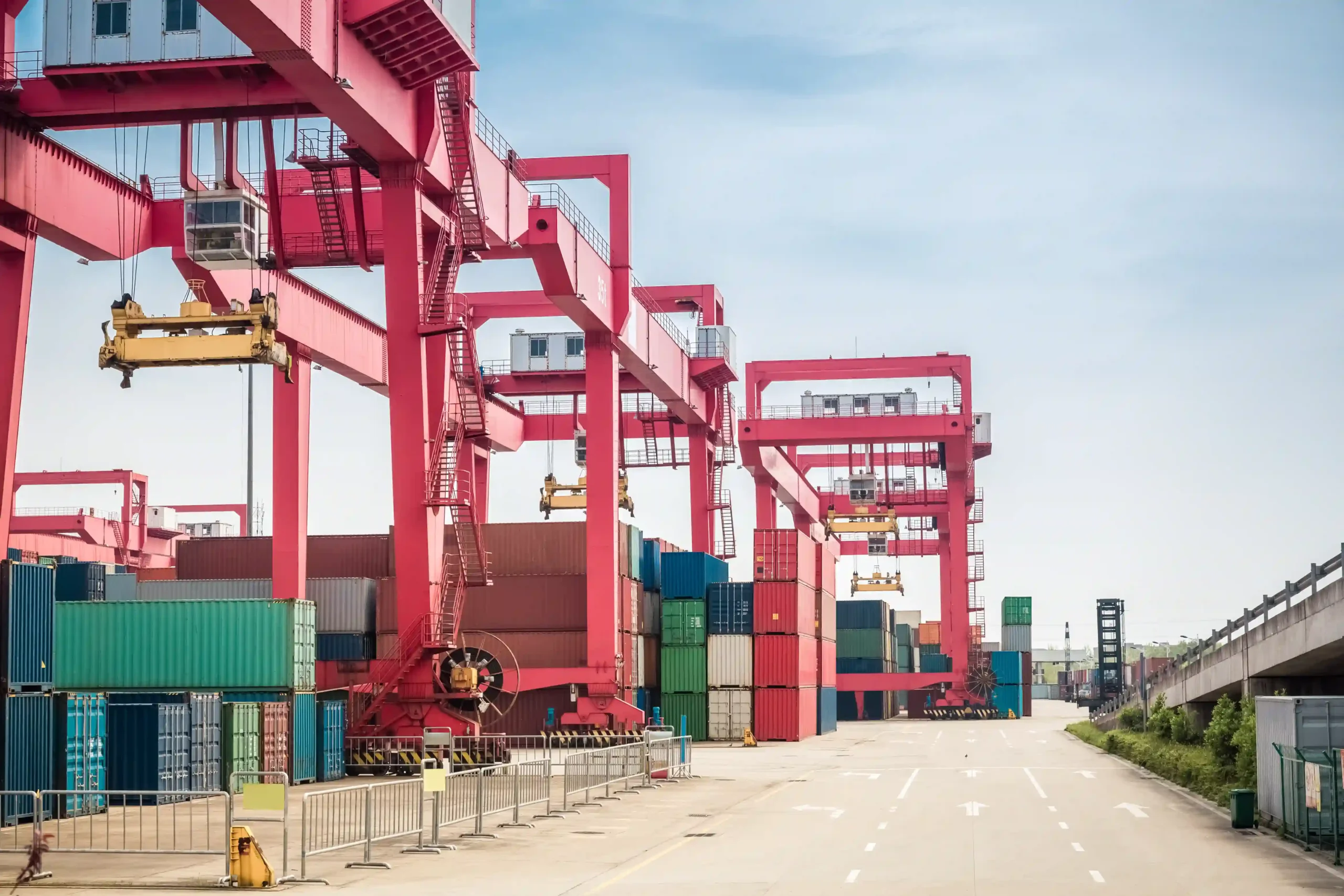 Automated cranes and stacked containers in an FTZ logistics freight yard, ready for global shipment