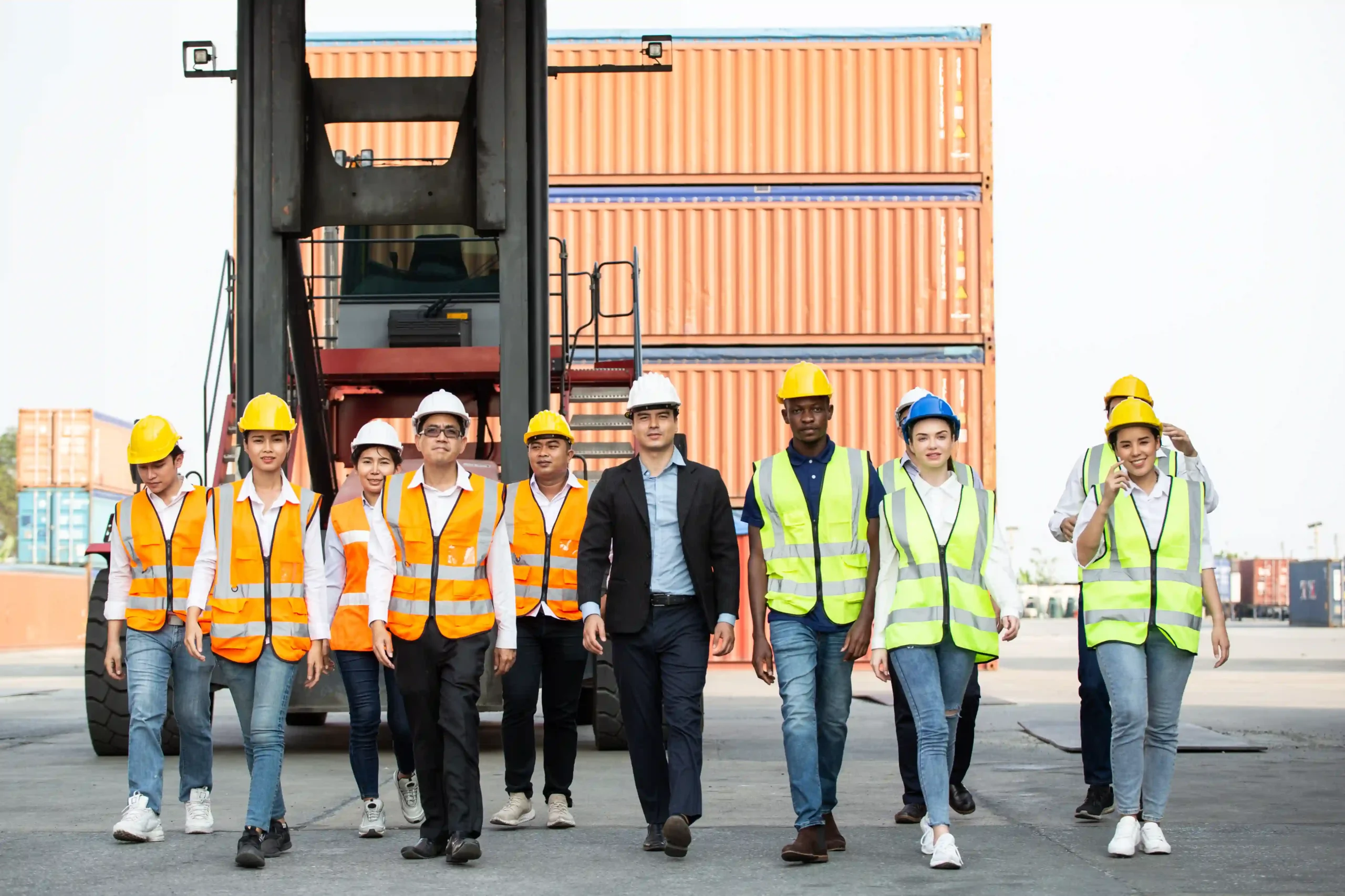 Diverse logistics team walking through a container yard as part of the 3pl logistics process