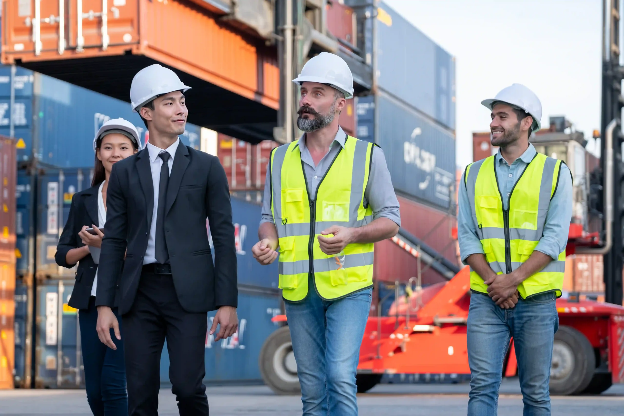 Business professionals and logistics managers discussing global trade compliance certification at a shipping container yard