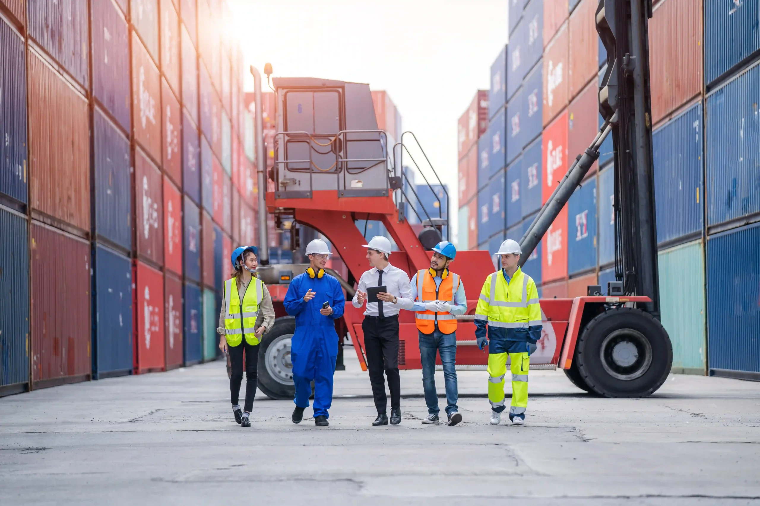 Logistics team walking through a container terminal while planning for global trade compliance certification