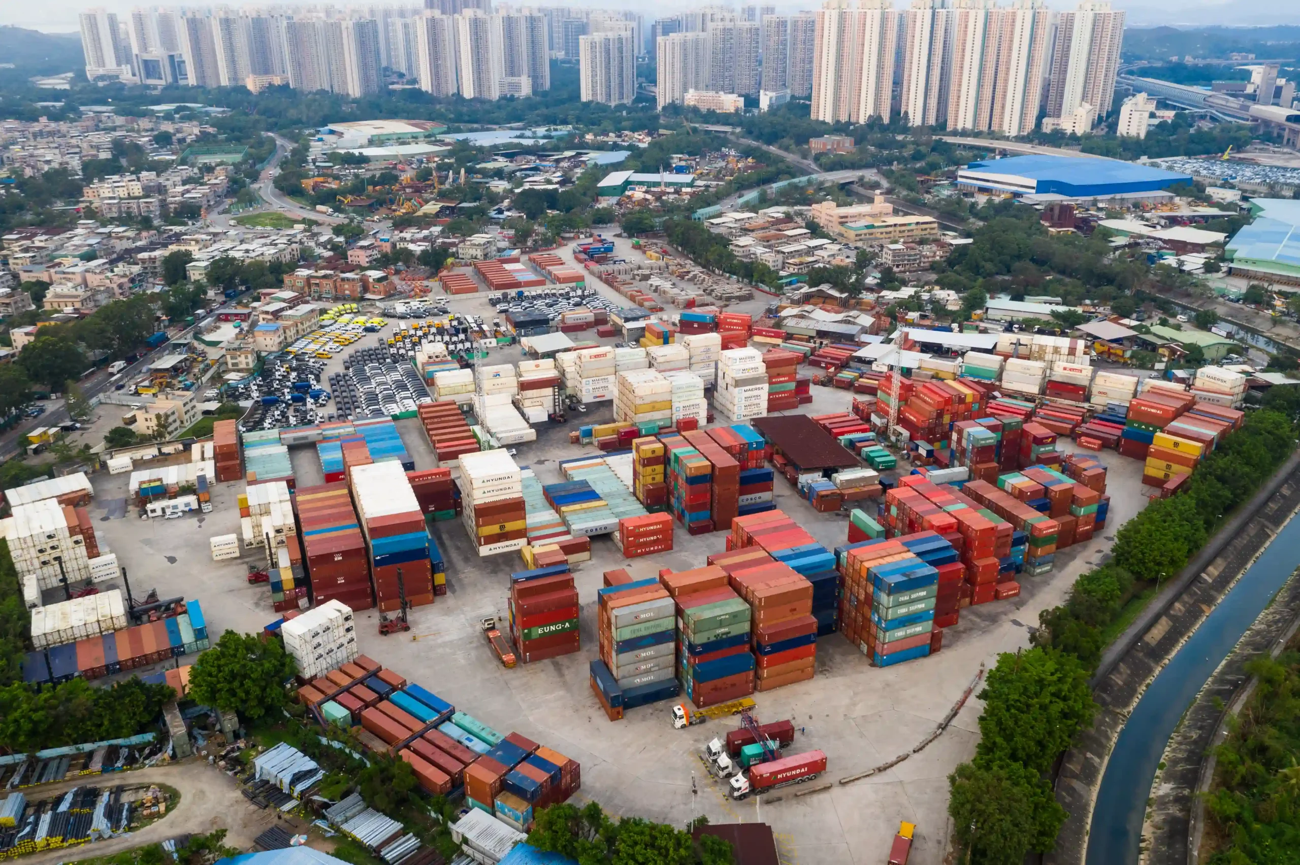 Large FTZ logistics container hub adjacent to high-rise cityscape, highlighting urban trade access