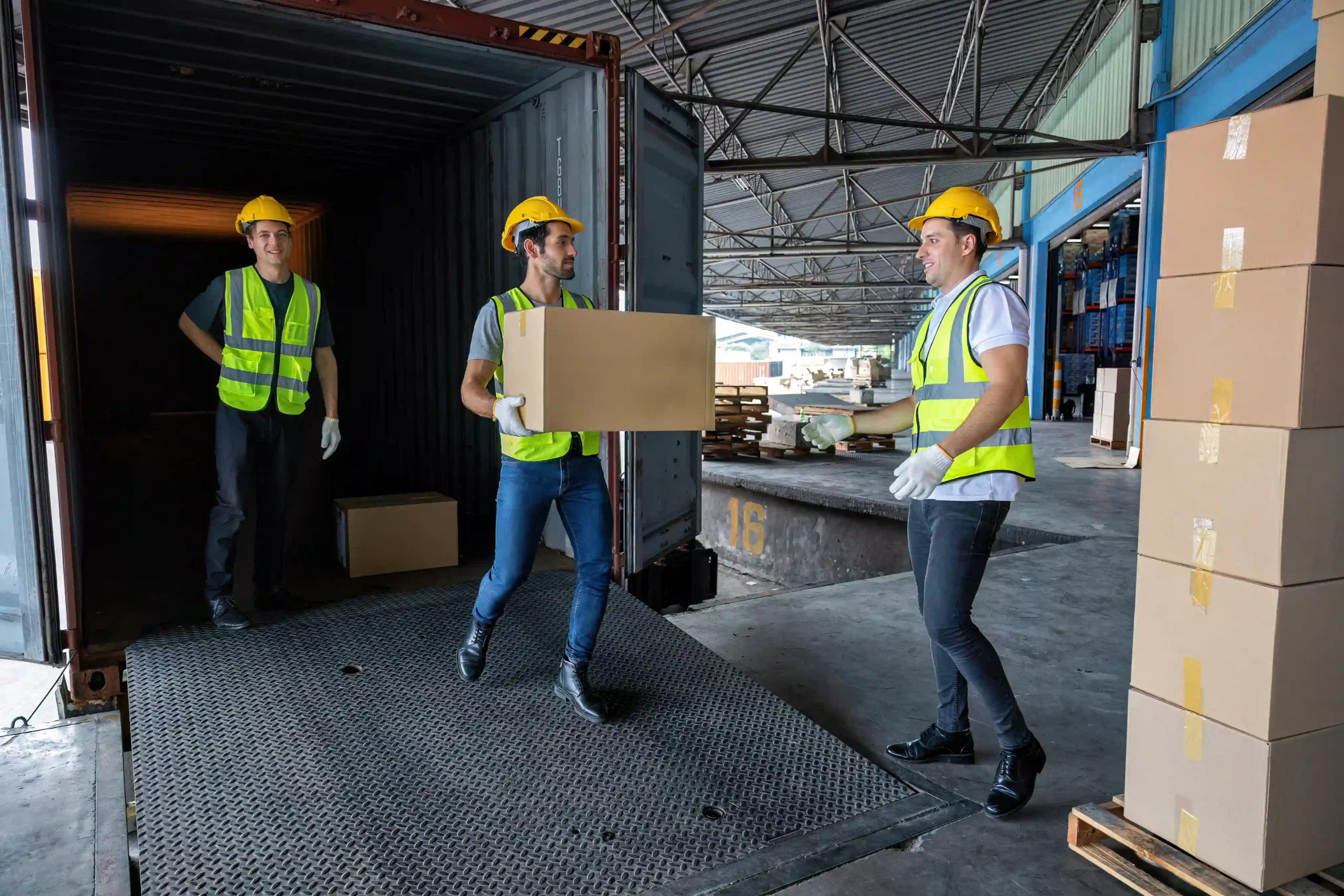 Workers unloading cartons from a shipping container at a fulfillment center, a key step in 3PL explained logistics