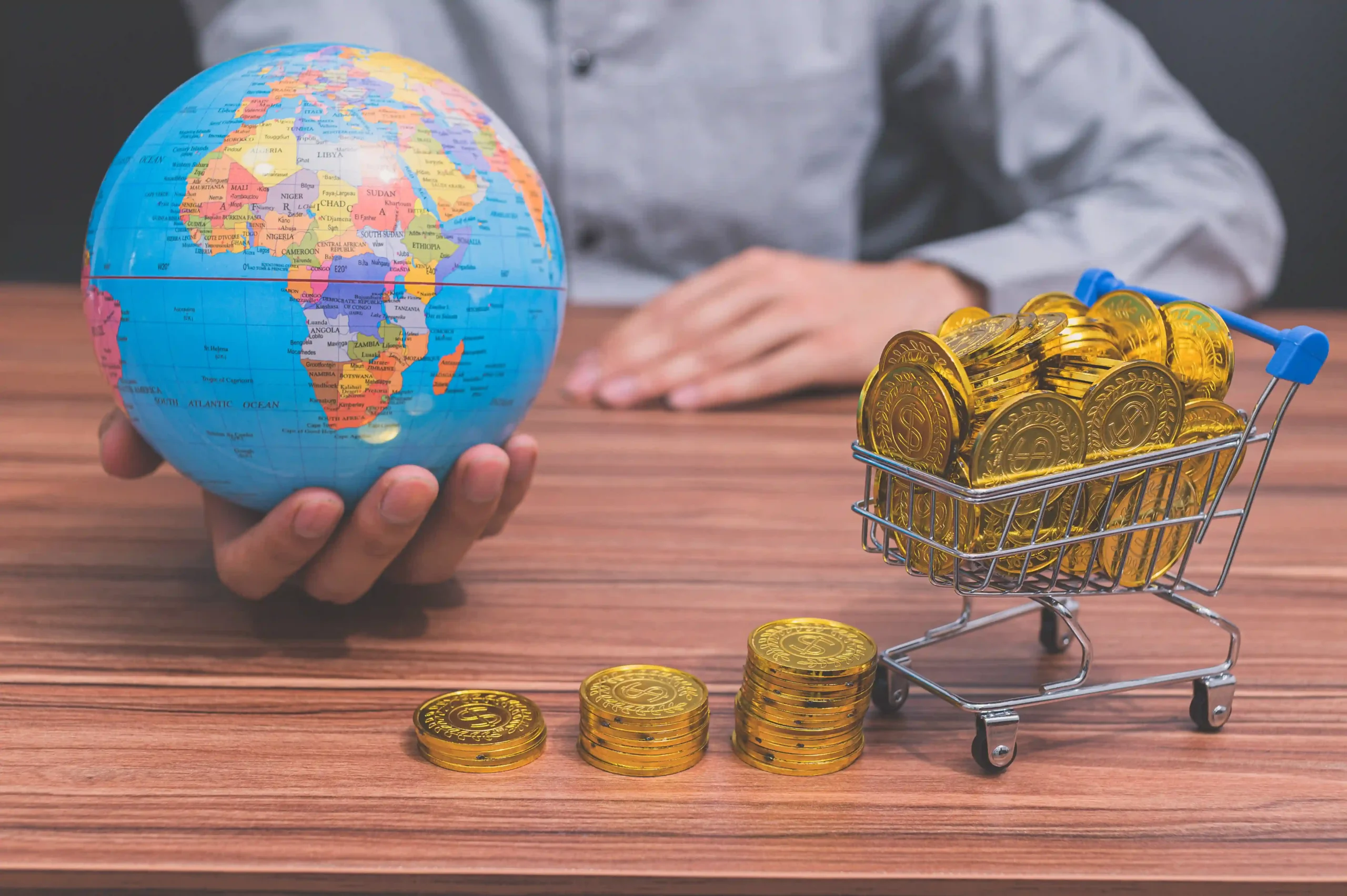 Business concept showing global trade and currency with globe and coins symbolizing the impact of a de minimis waiver on imports.