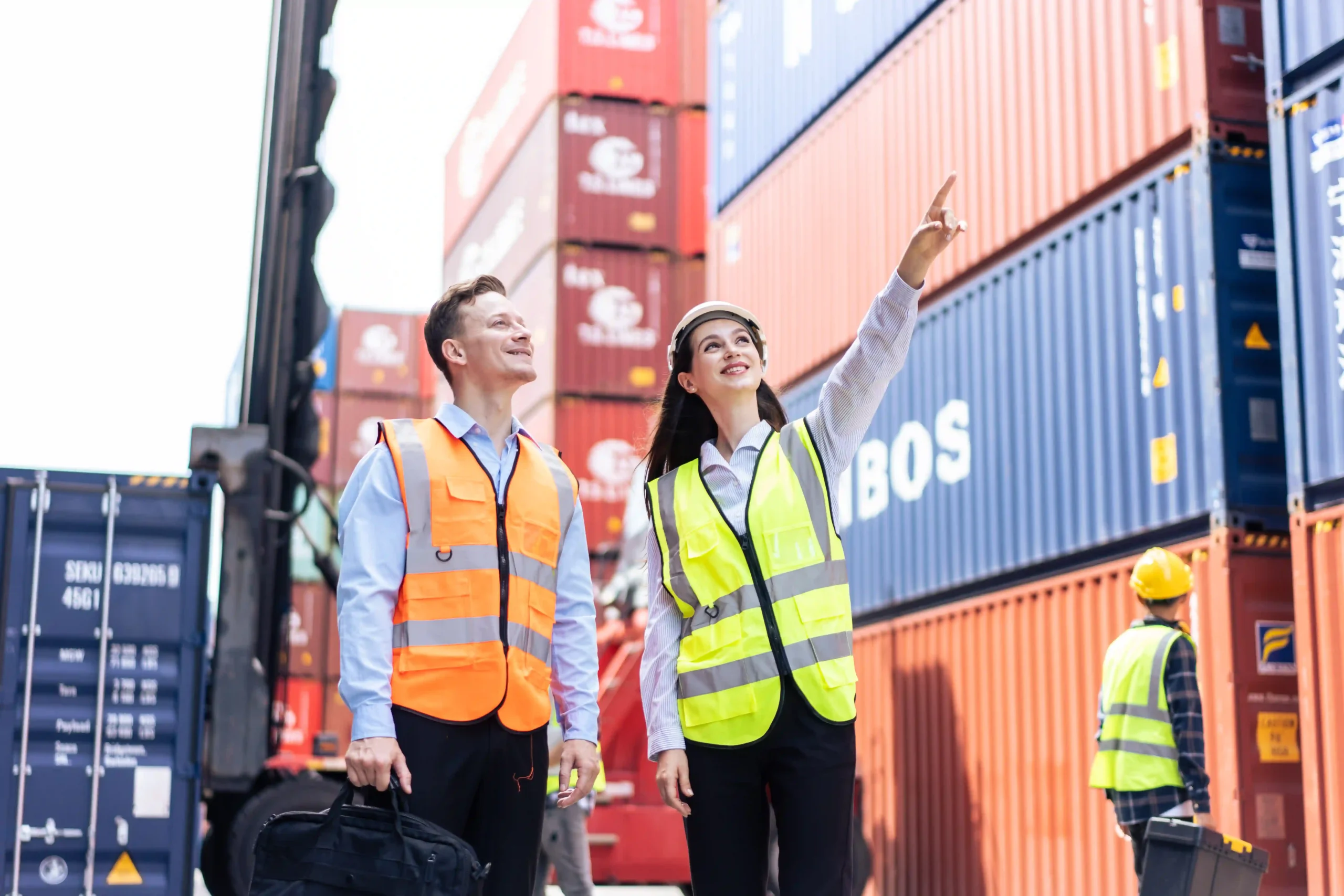 Supervisors at shipping yard discussing container operations, connecting supply chain management to what does de minimis mean in tax.