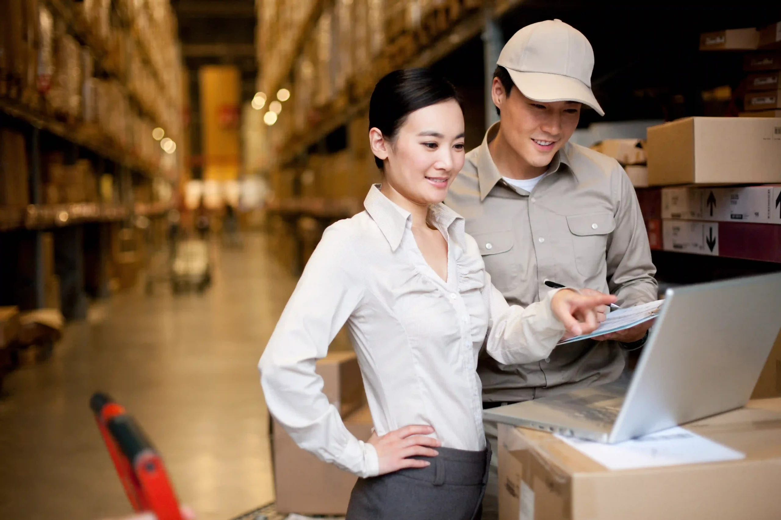 Logistics manager and worker checking shipment details to ensure accuracy with de minimis US customs documentation.