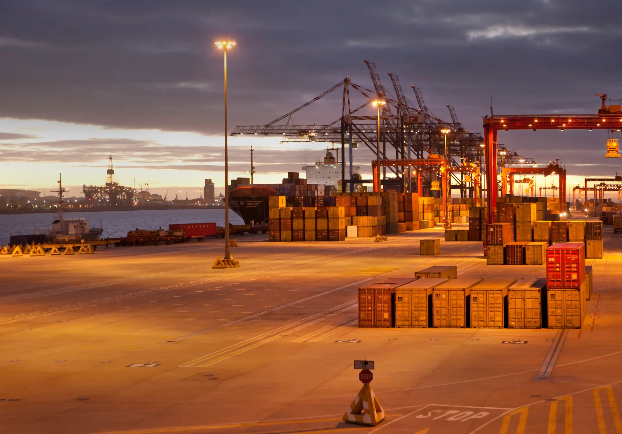 Shipping terminal with cranes and stacked containers adapting to de minimis release customs enforcement.