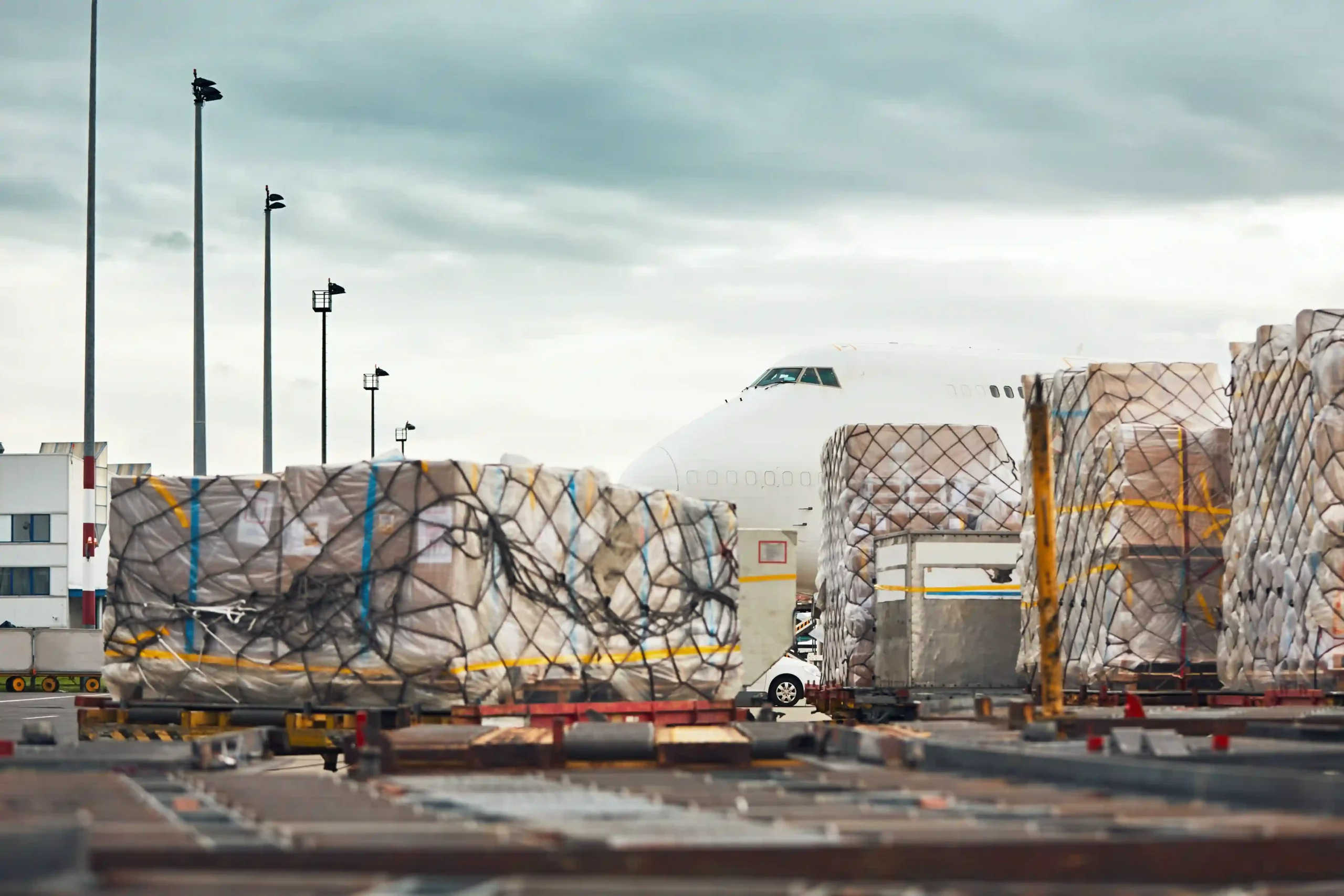 Air cargo pallets prepared for export at airport, reflecting international trade impacted by de minimis oid regulations.