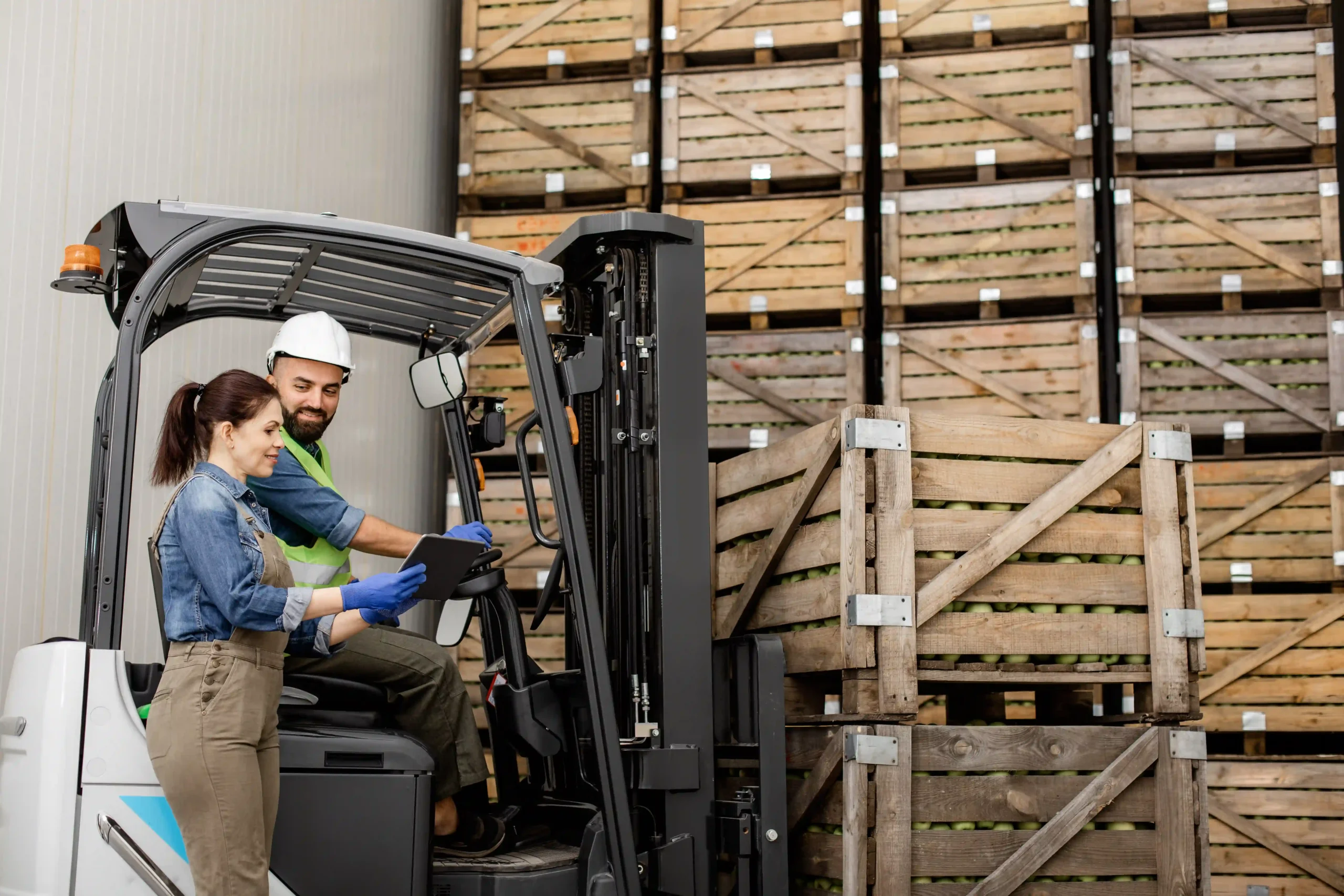 Warehouse workers using forklift to manage goods while learning what is de minimis in tax for supply chains.