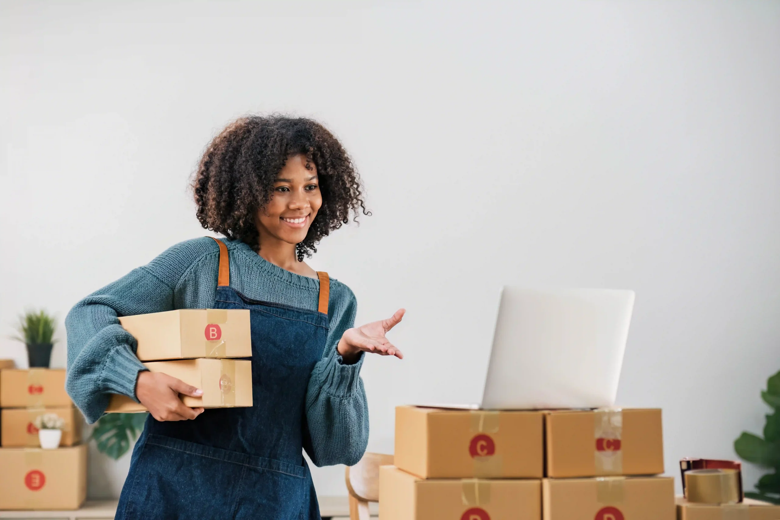 Small business owner holding packages while selling online shows how entrepreneurs are impacted by the de minimis standard.