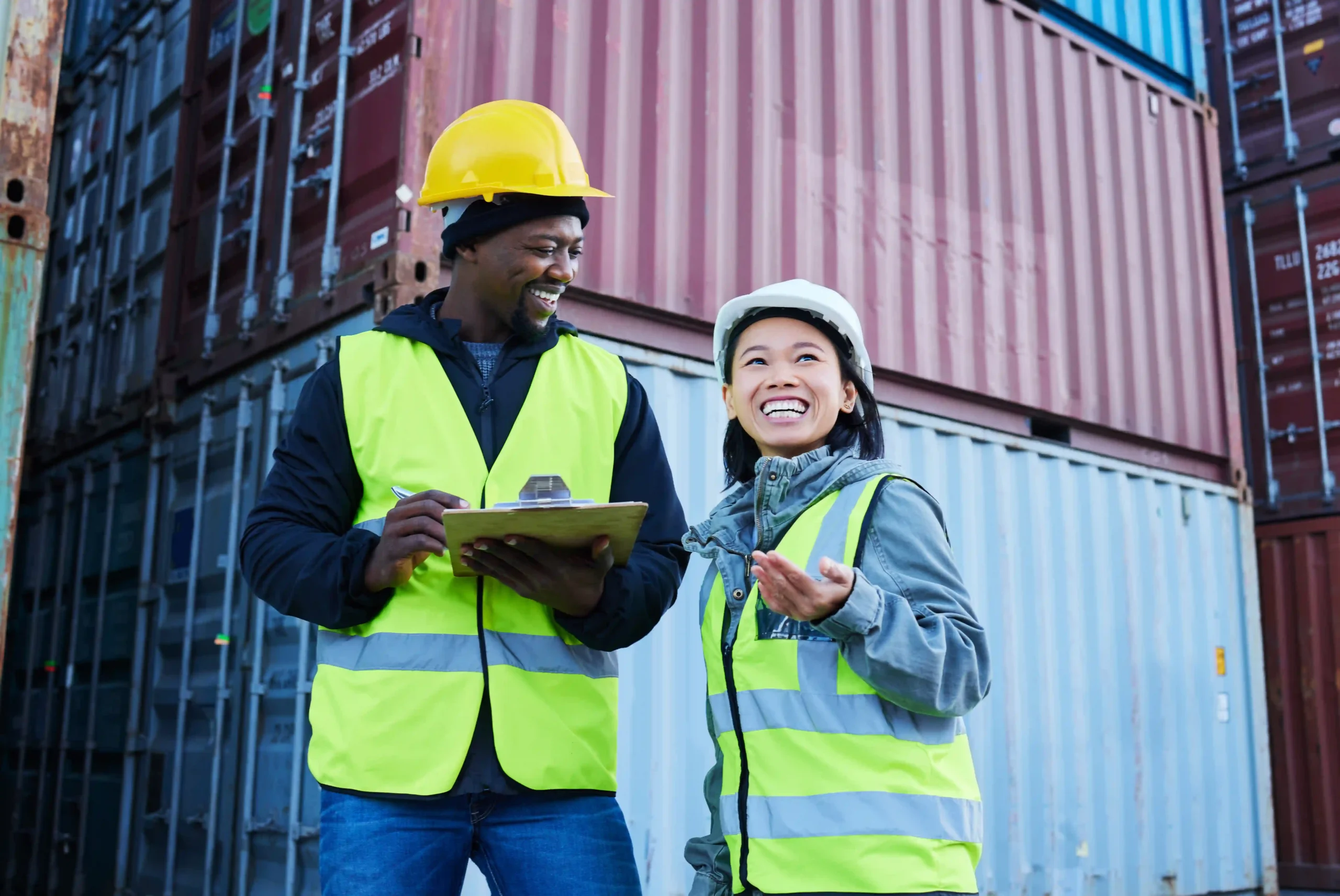 Logistics workers reviewing shipment paperwork at a container yard during de minimis release policy changes.