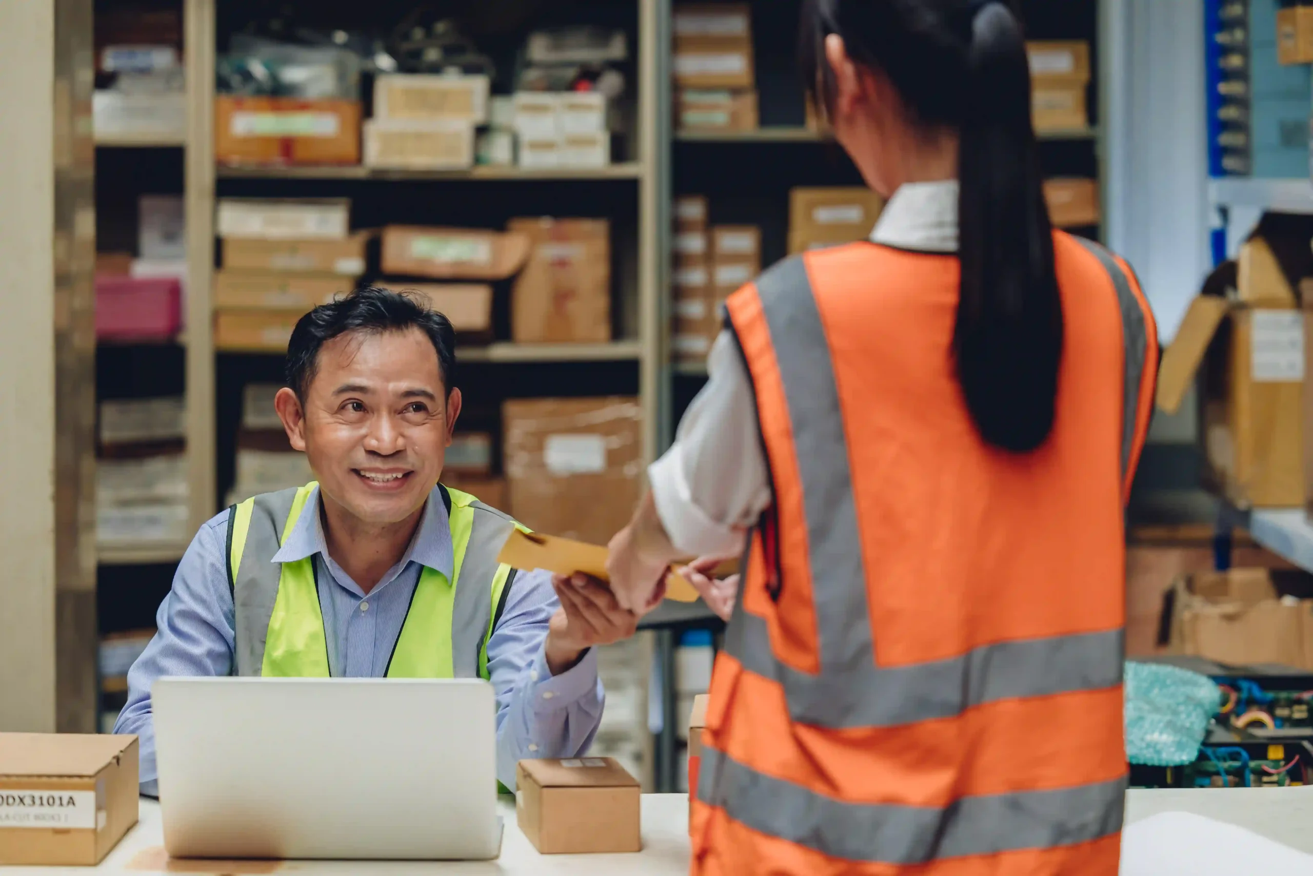 Warehouse manager handing a package to staff, representing logistics operations under what is the the de minimis exemption.