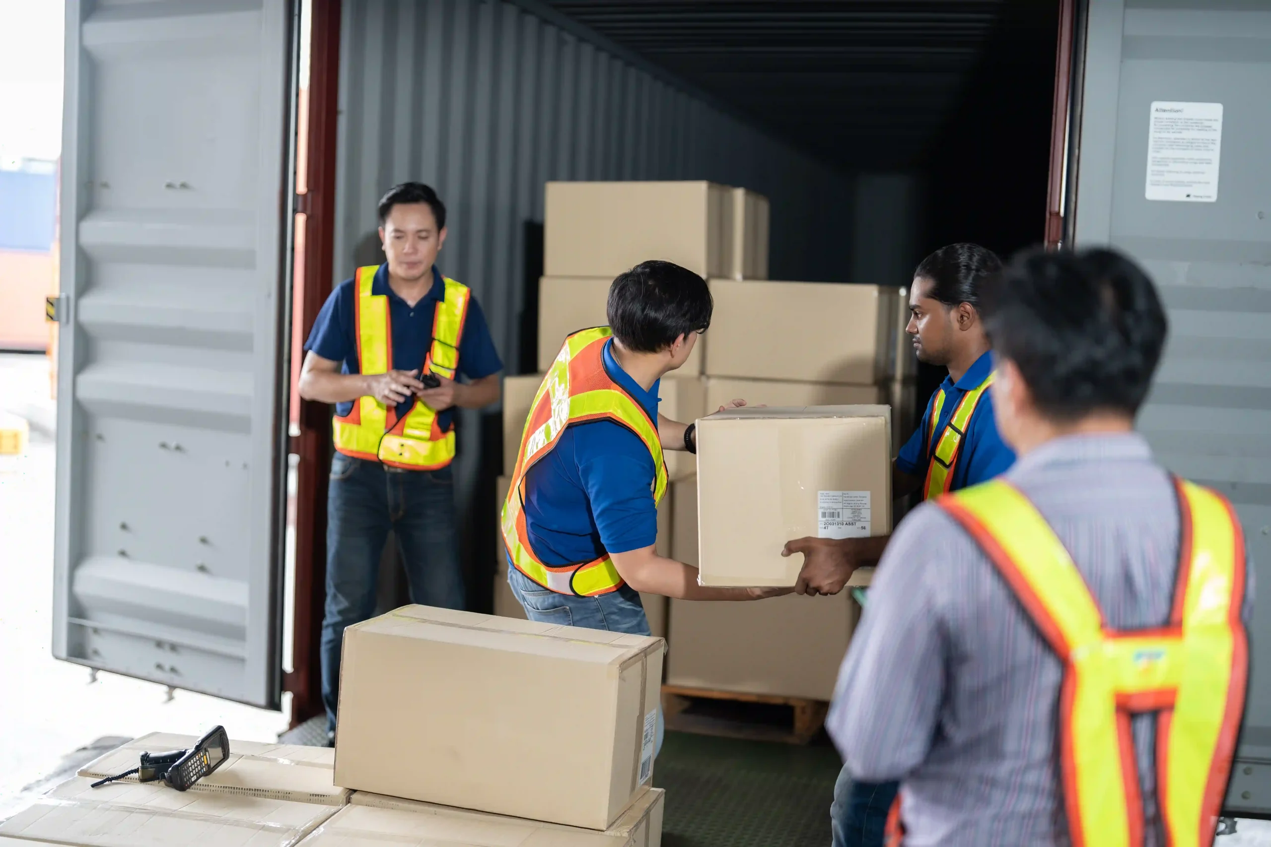 Workers loading cargo into a shipping container, showing logistics challenges after the de minimis update.