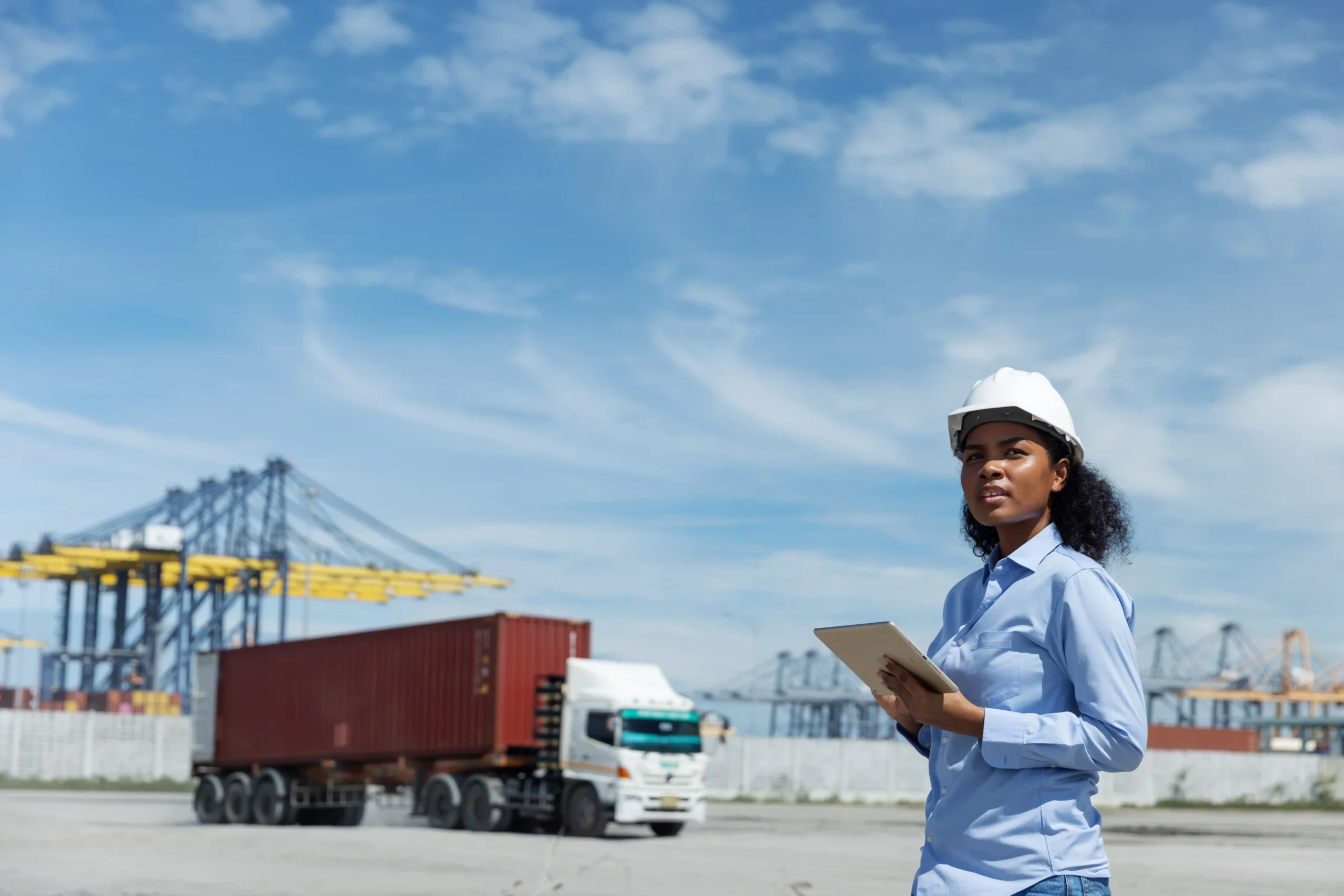Logistics supervisor inspecting container trucks at a port while reviewing compliance steps to avoid Section 321 duties.