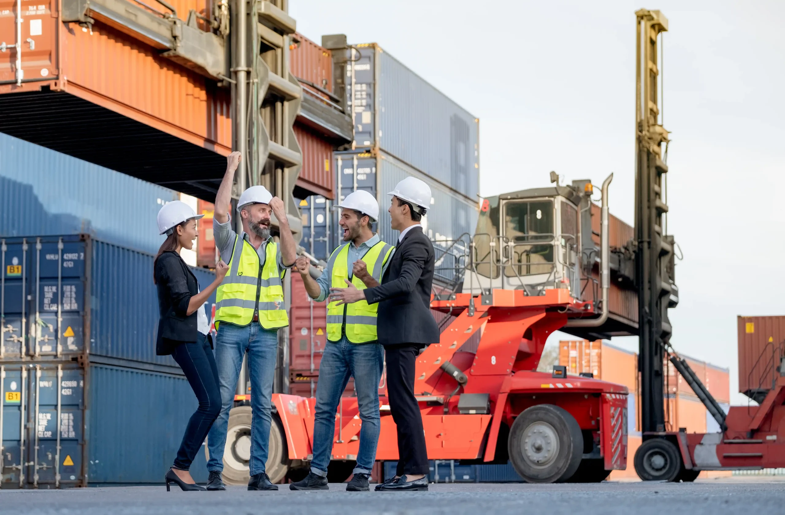 Workers celebrating successful freight operations at a busy shipping yard, illustrating supply-chain adjustments after the duty-free threshold abolished policy.