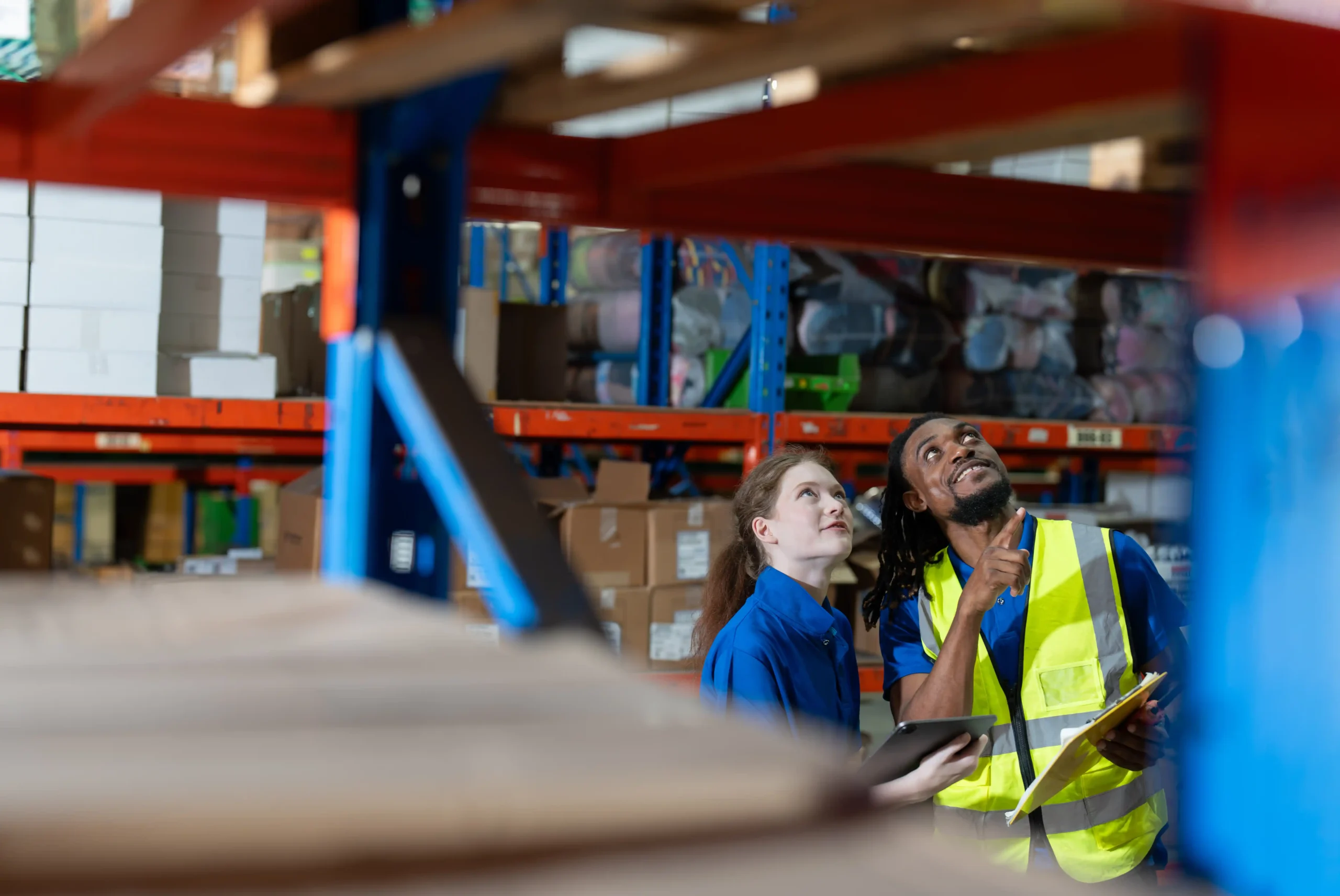Supervisors reviewing inventory racks inside a small warehouse building.